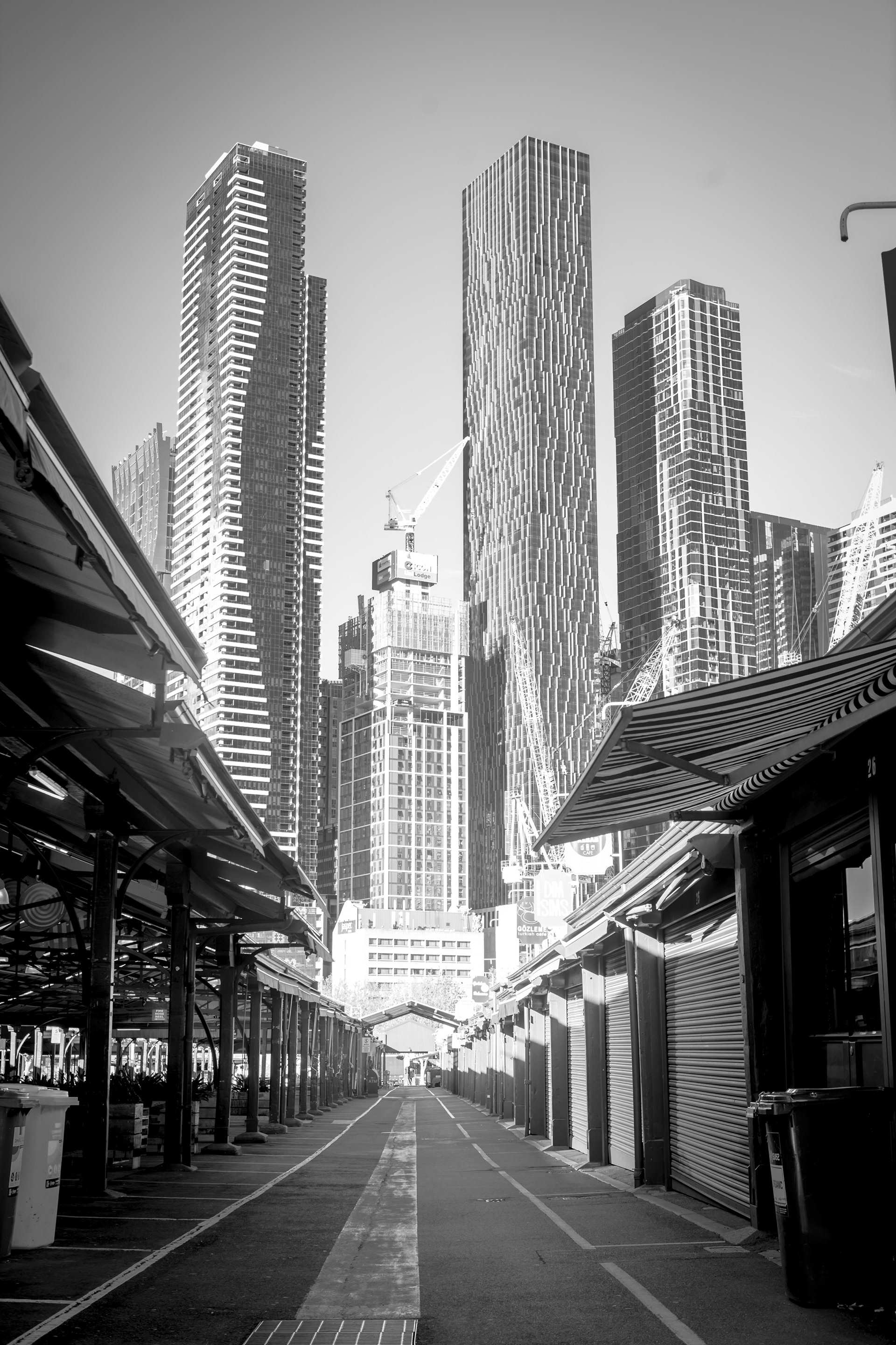 Black-and-white view of skyscrapers from a market walkway