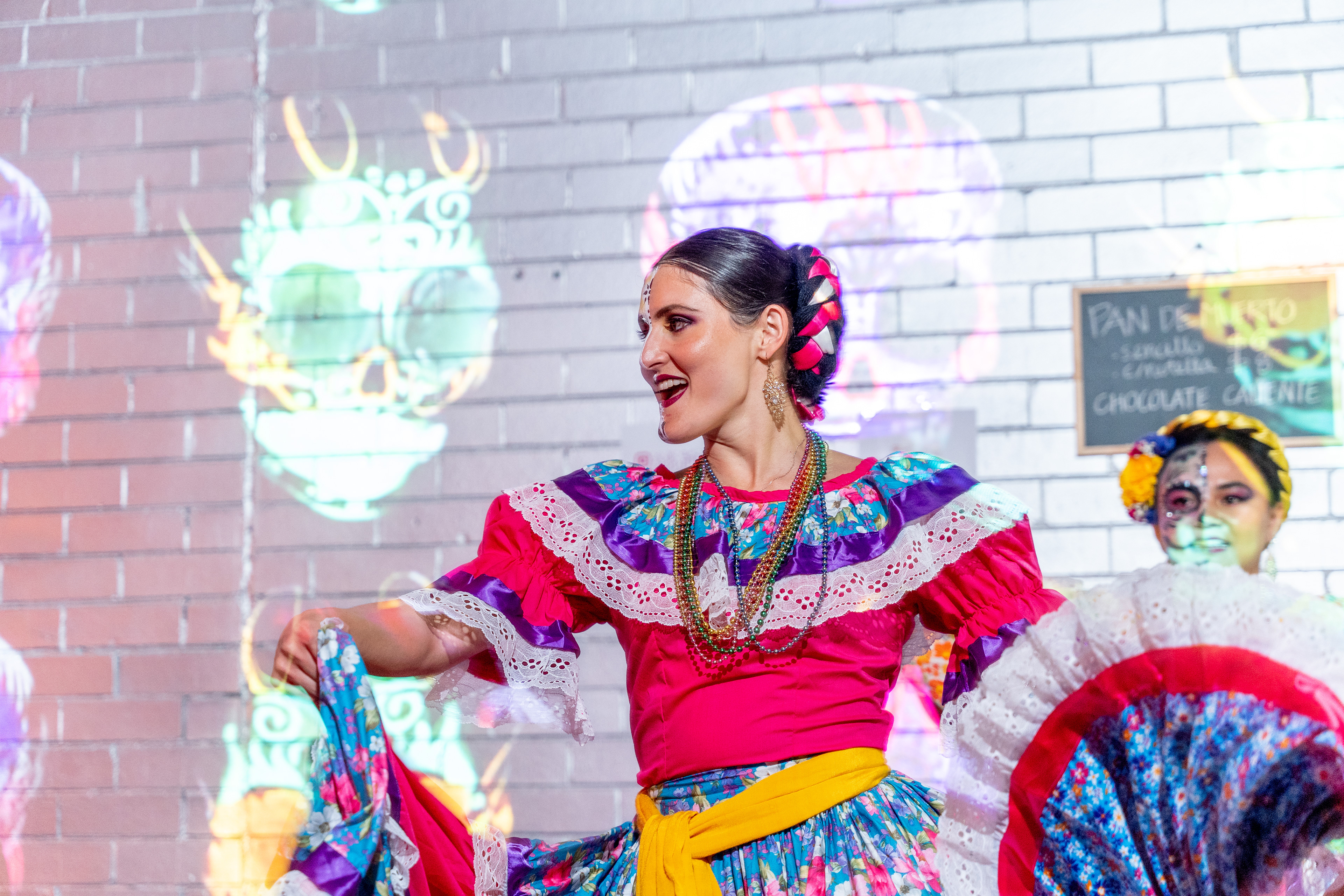 Dancer in a colourful dress performing at a cultural event