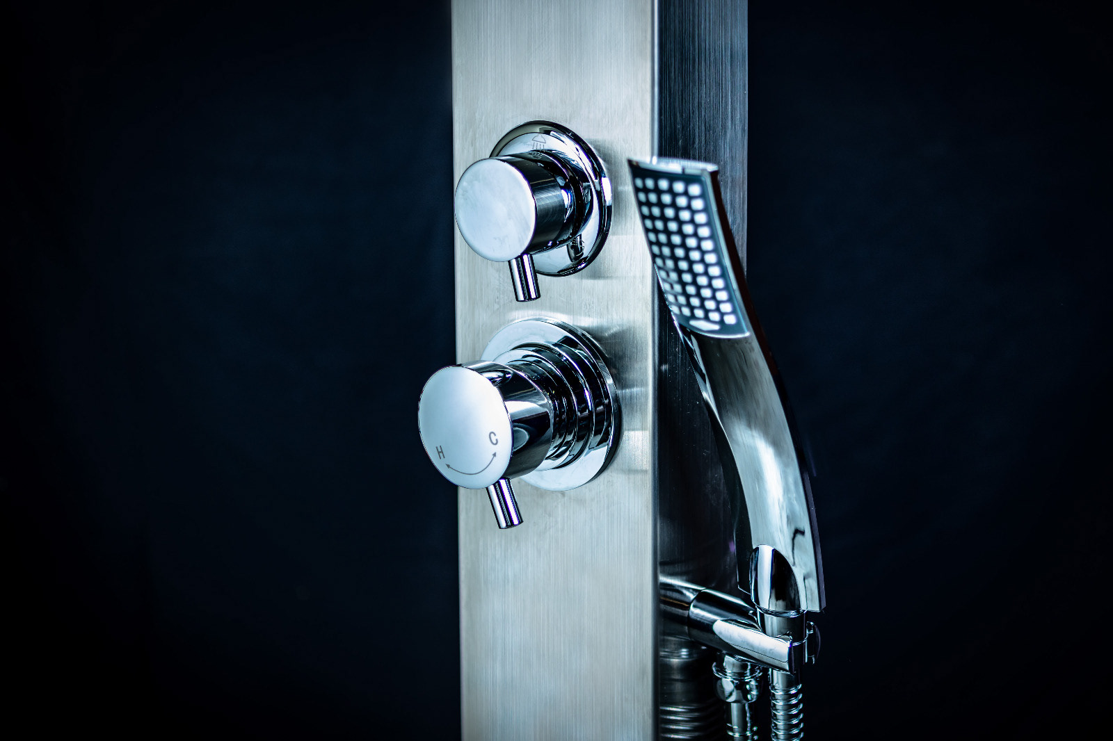 Chrome shower fittings photographed against a dark background