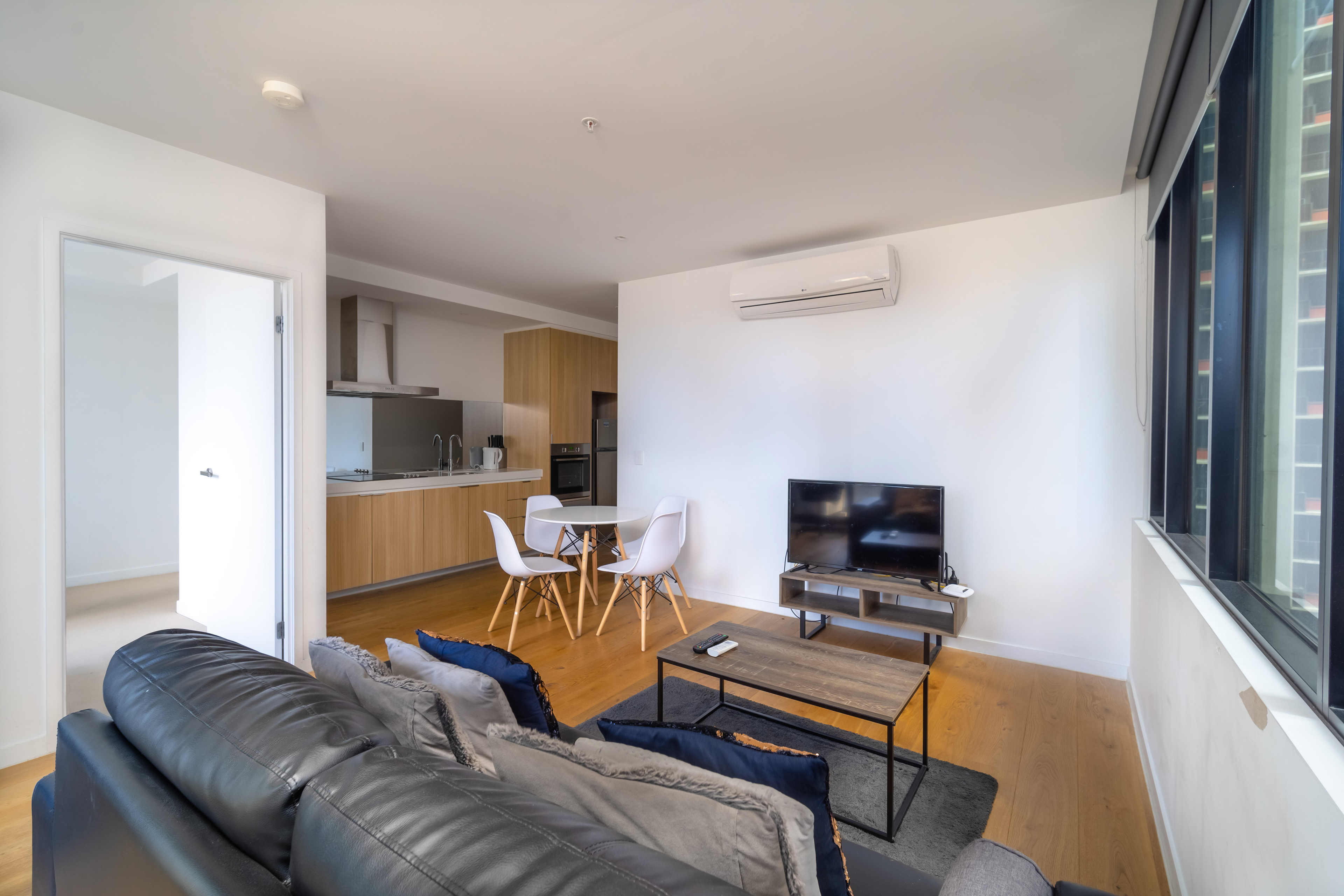 Open-plan apartment with a grey sofa and compact kitchen