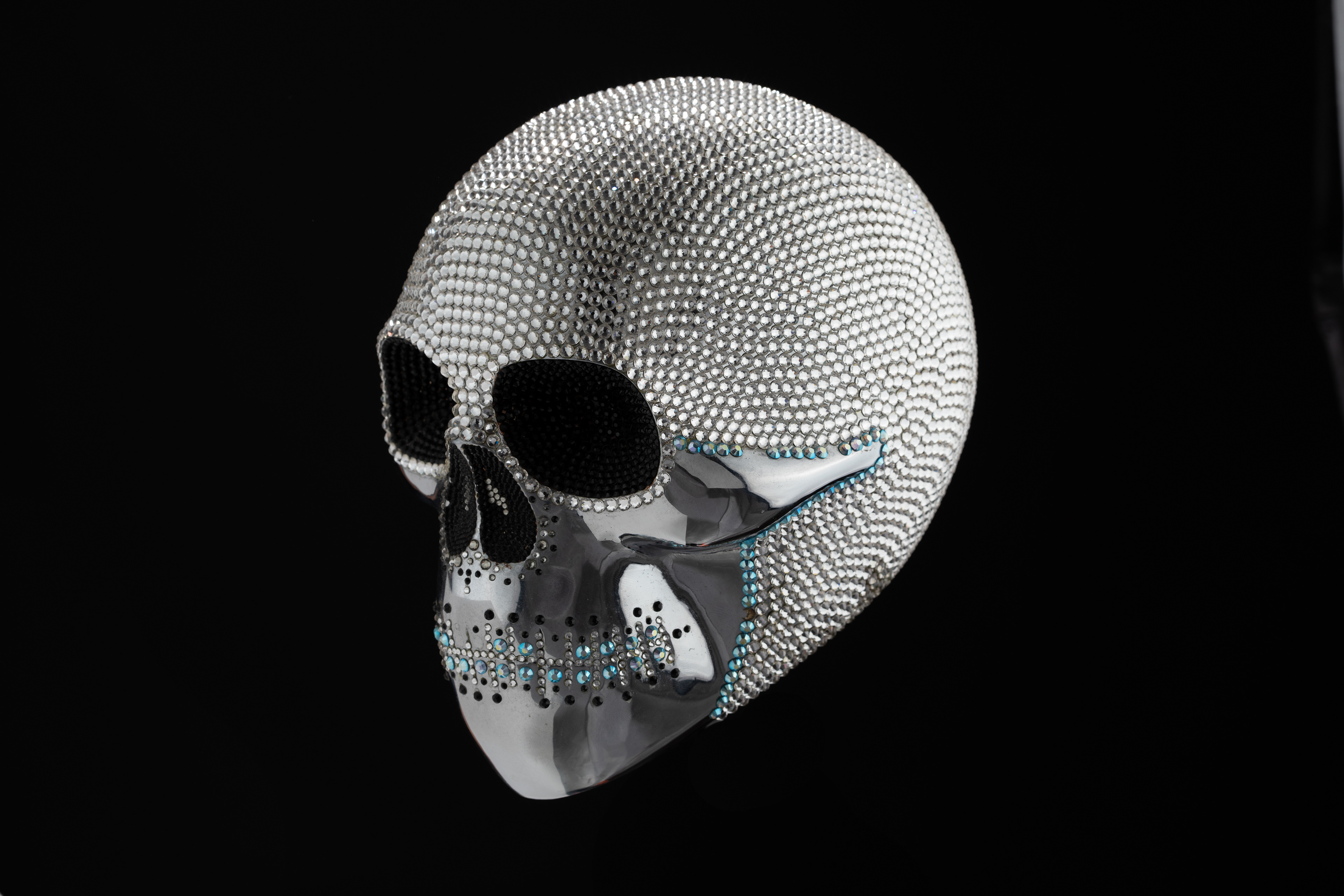 Side view of a white beaded skull against black