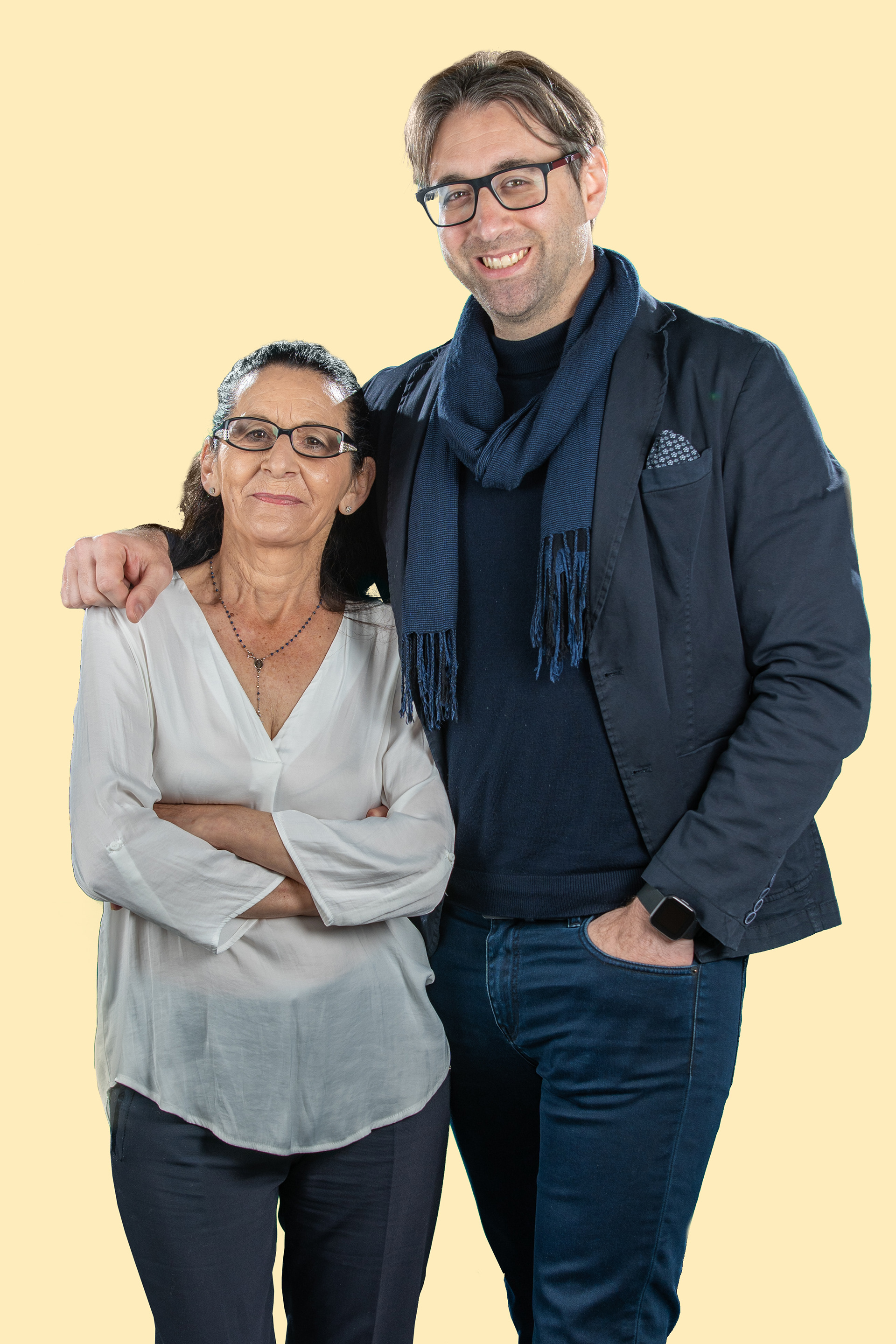 Couple posing together against a pale yellow background
