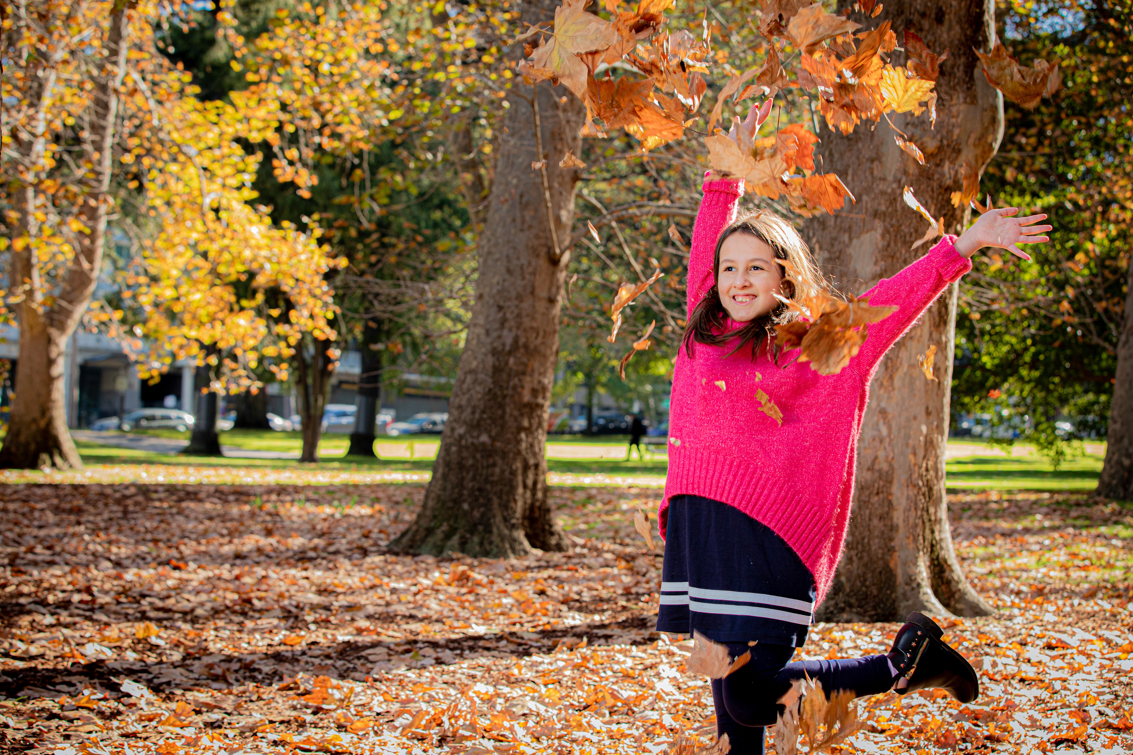 Family playing together beneath colourful autumn trees