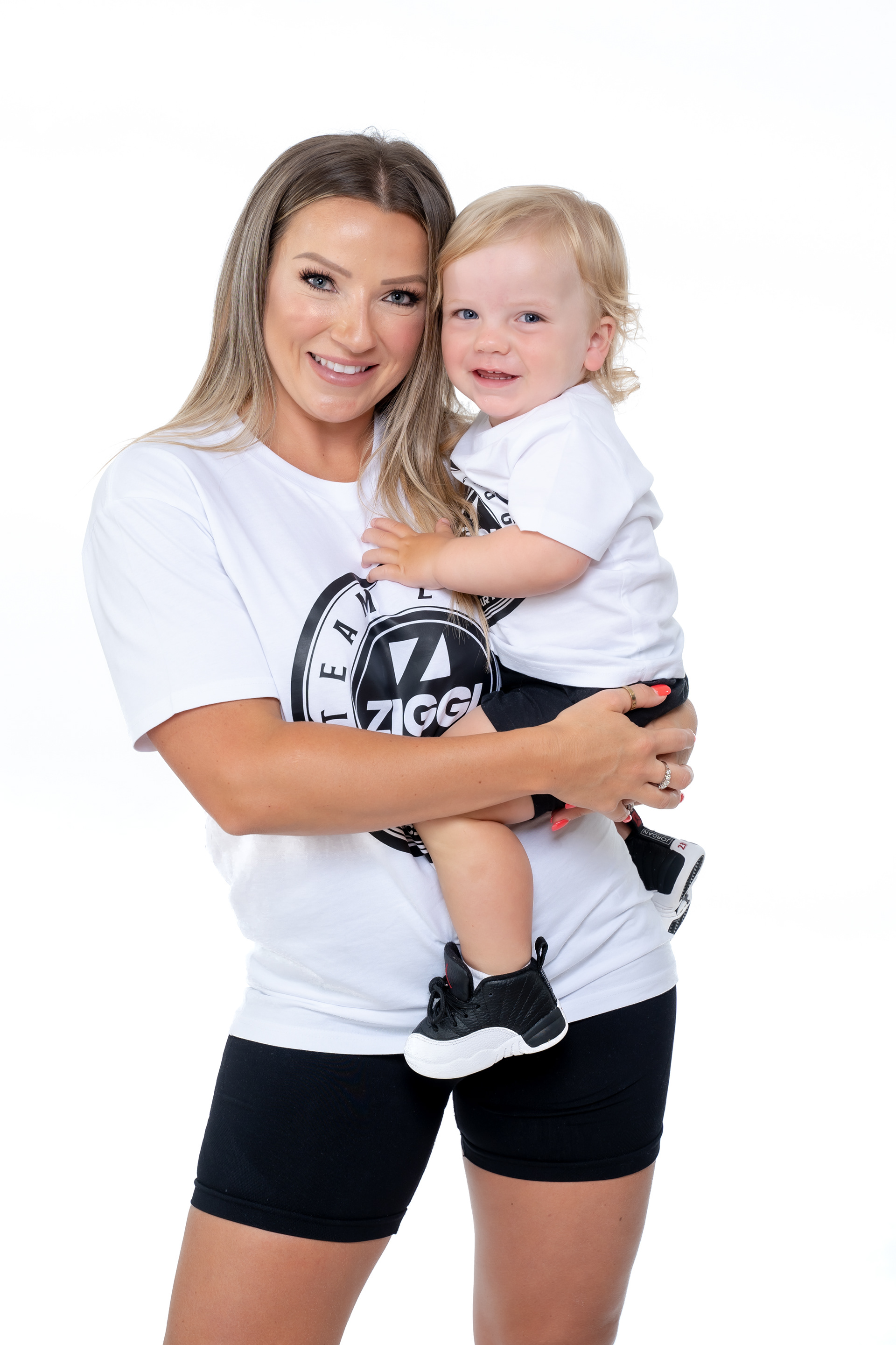 Parent holding a child while wearing matching sports T-shirts