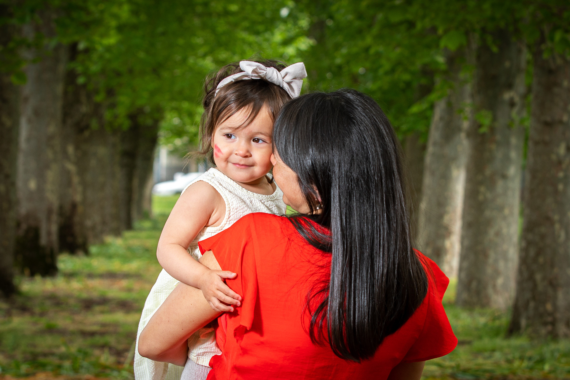 Parent holding a child while wearing a red dress