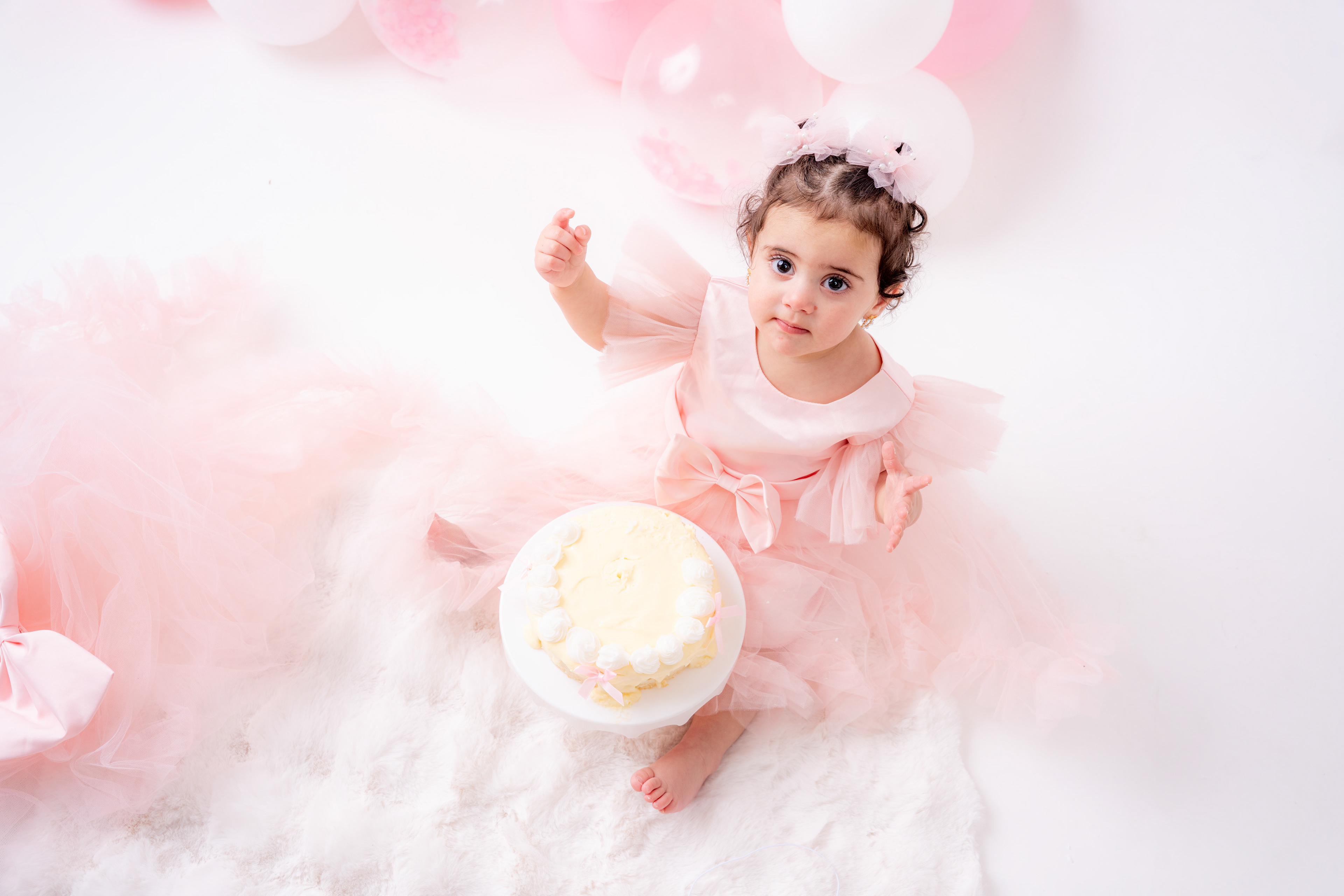 Baby sitting among soft pink decorations