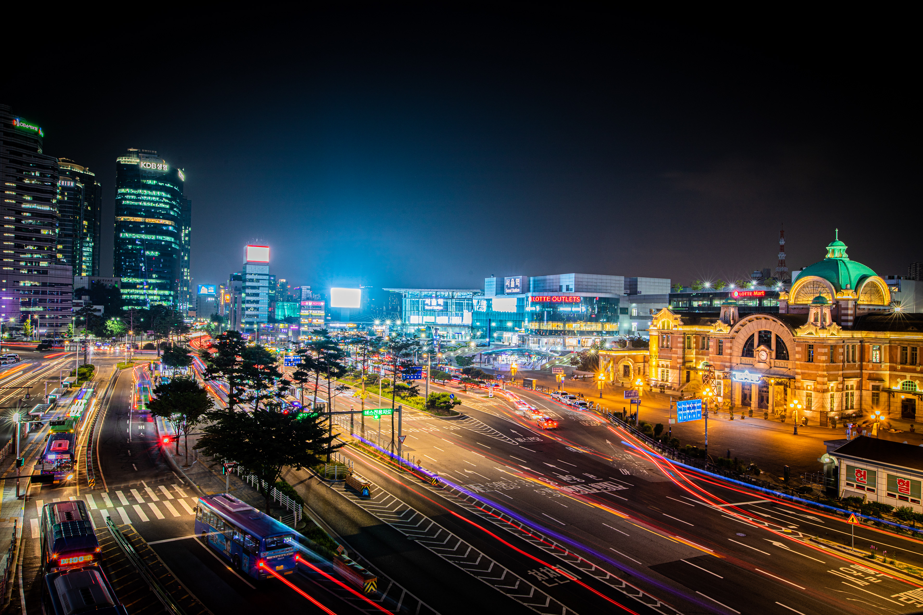 Night traffic passing illuminated buildings