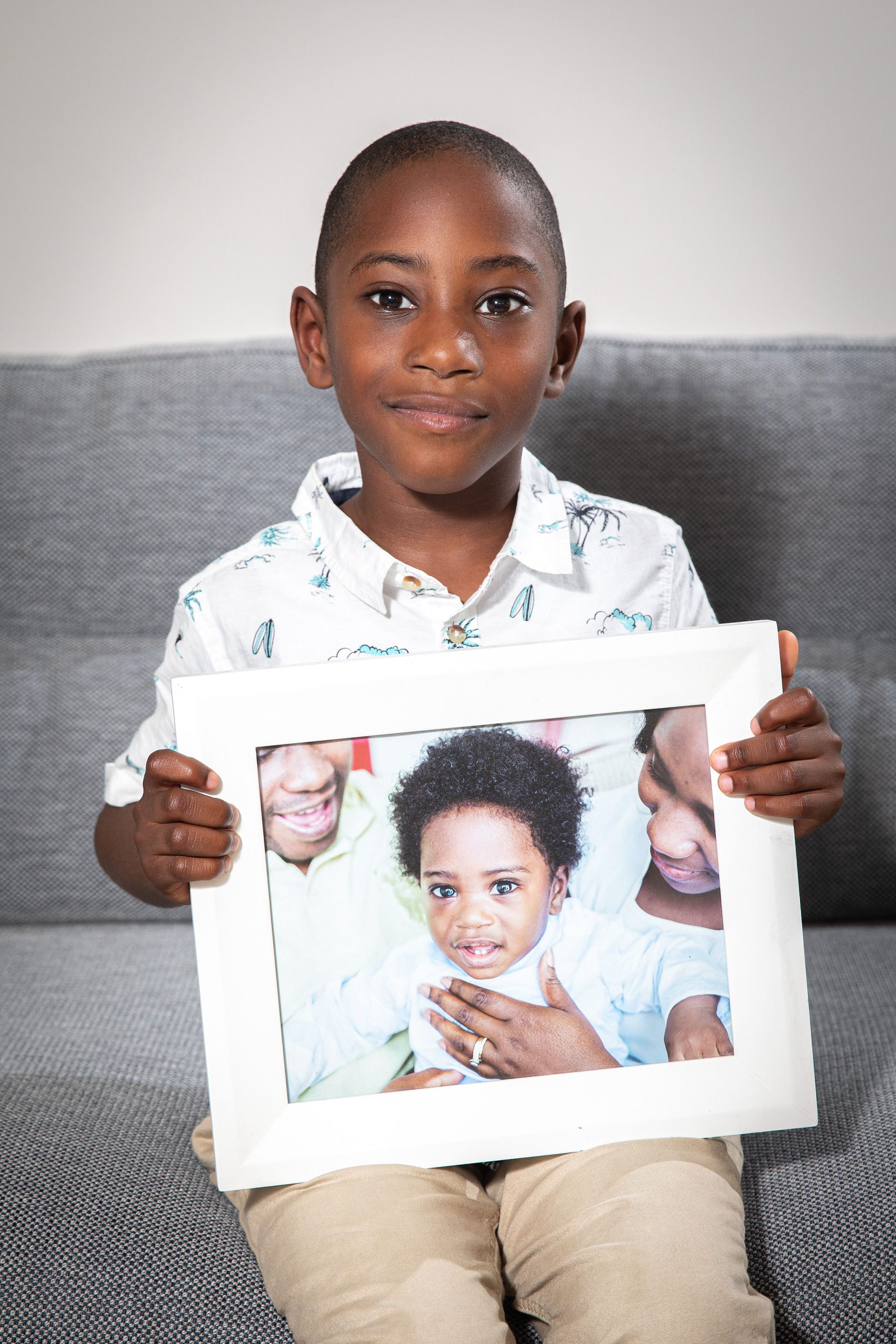 Child holding a framed family photograph