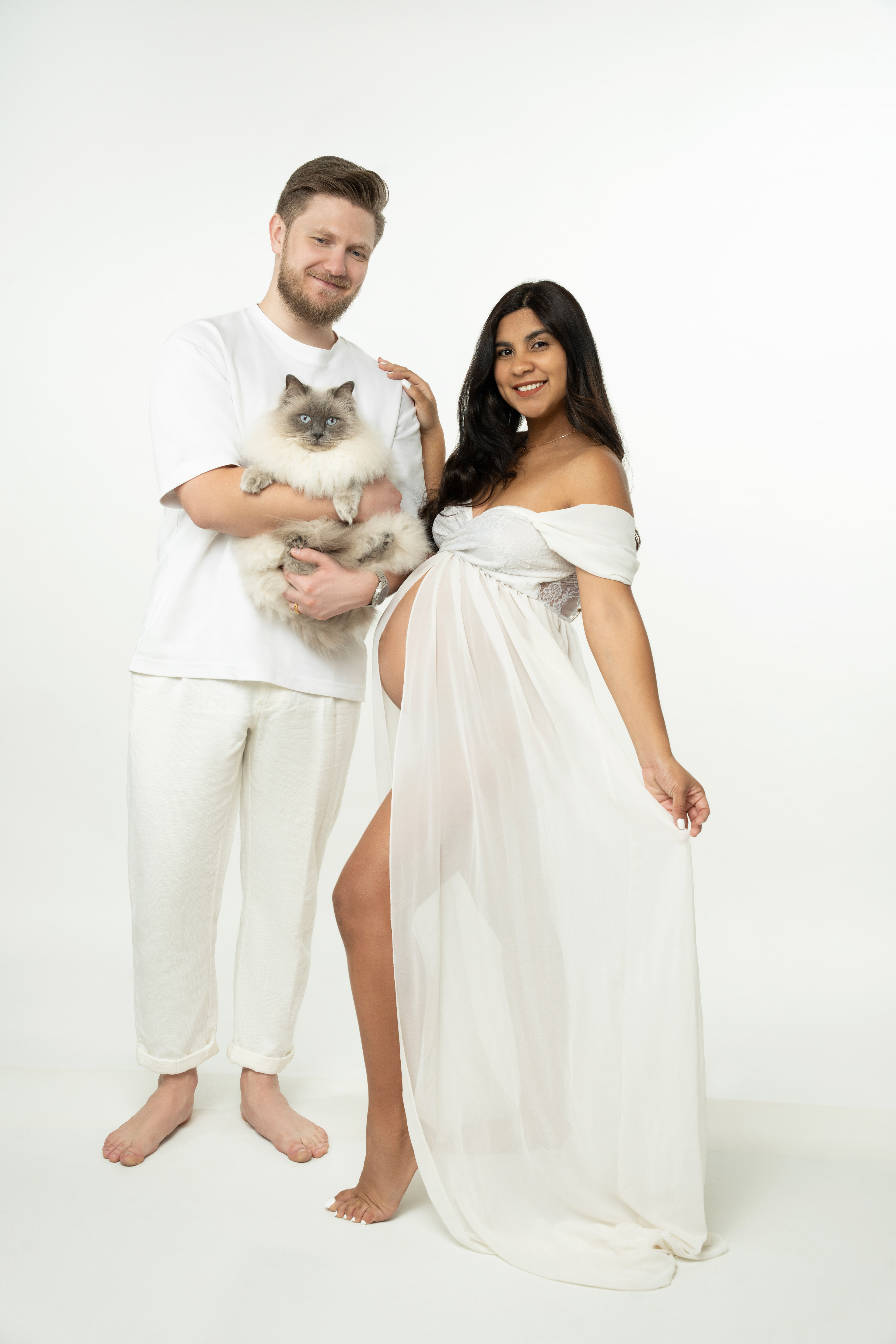 Full-length studio portrait of a couple in light clothing