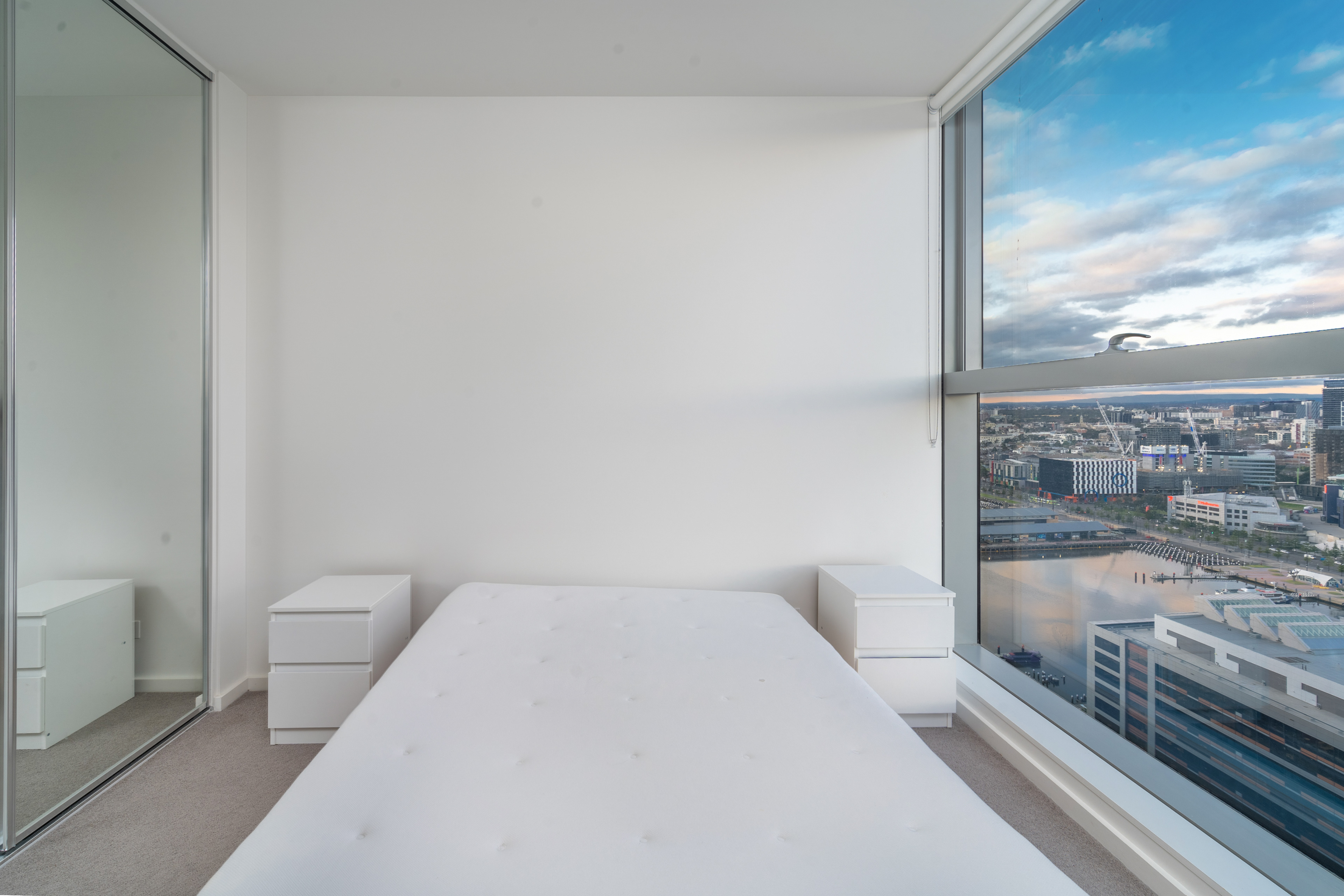 Bedroom with a large window overlooking the city