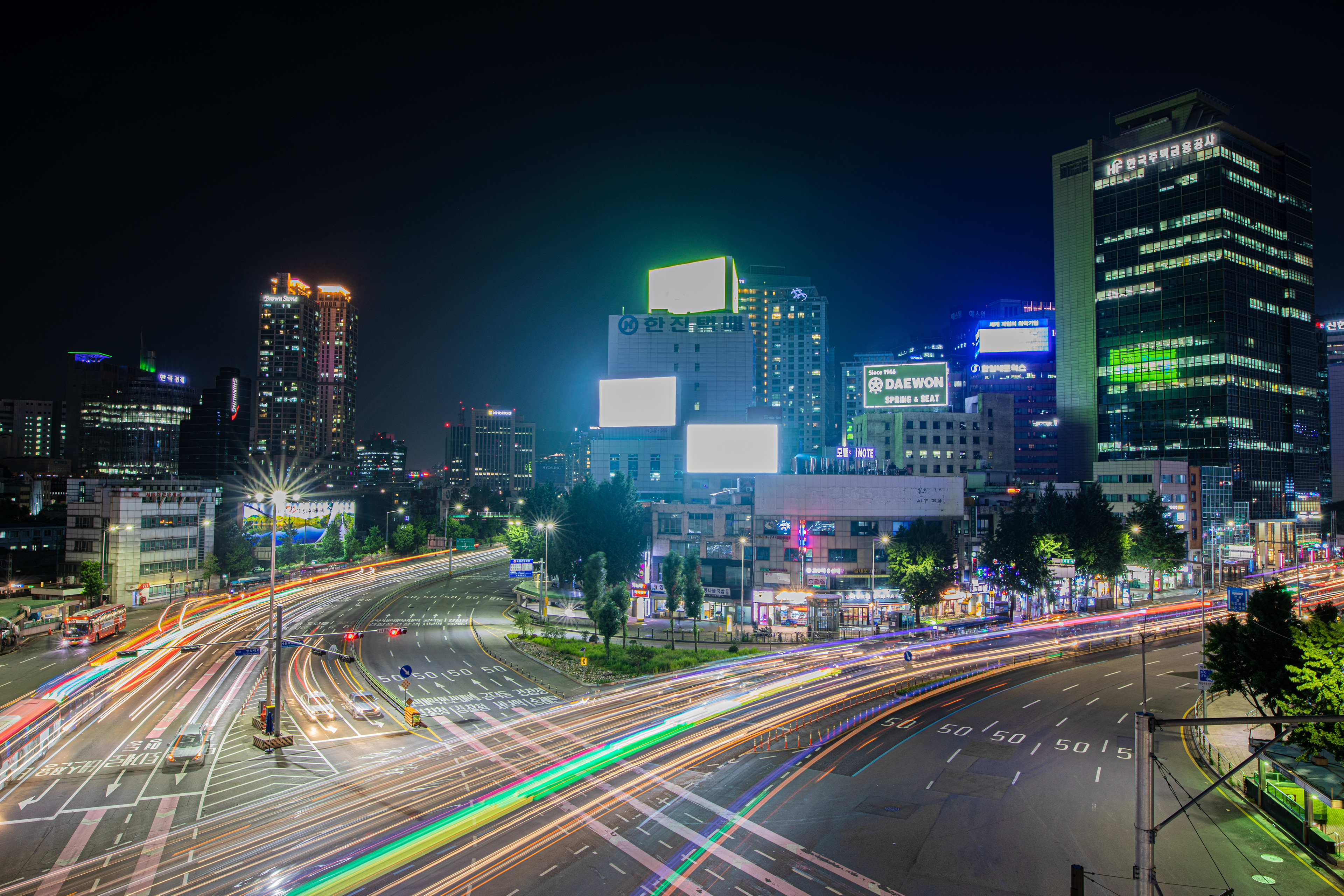 Light trails beneath tall city buildings at night