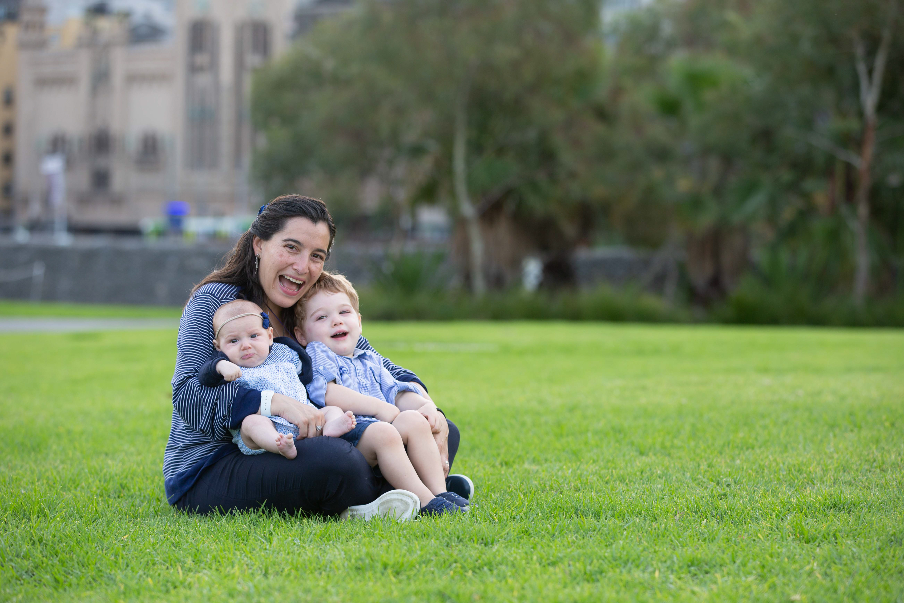 Family sitting close together on a green lawn