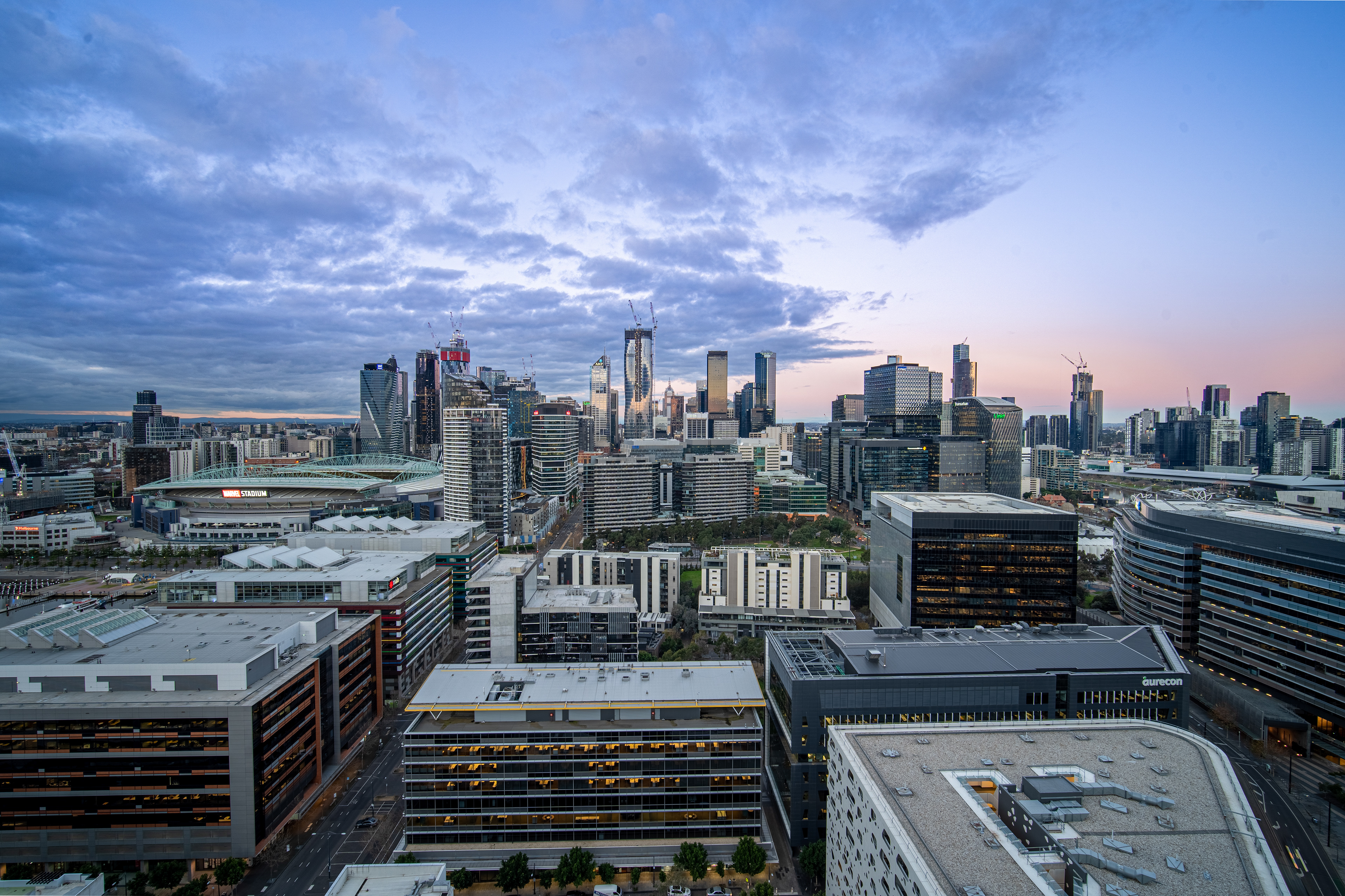 Wide city skyline beneath a blue and purple evening sky