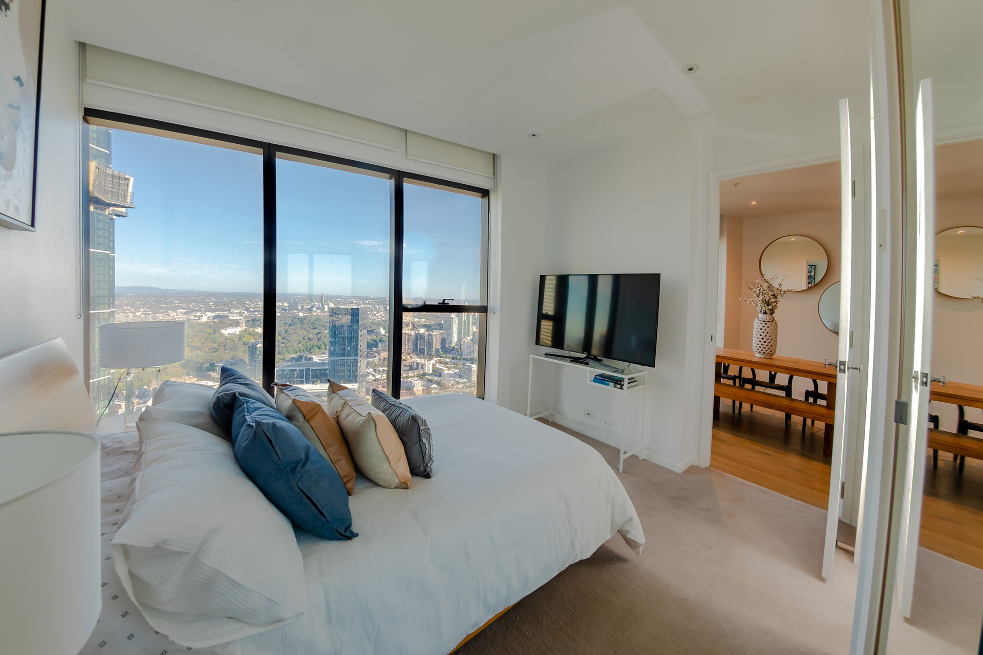 Apartment bedroom with floor-to-ceiling windows and city views