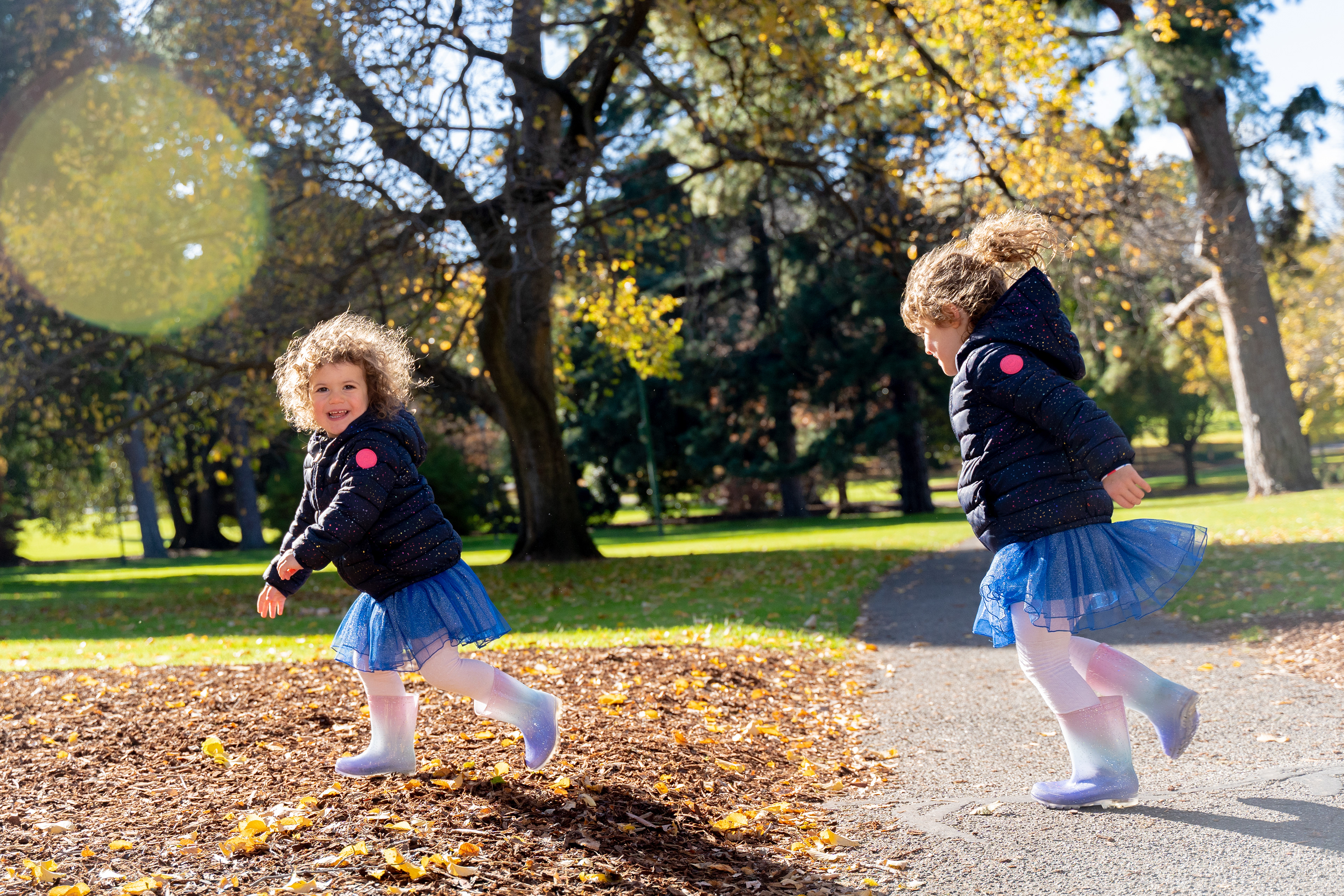 Children playing beneath autumn trees