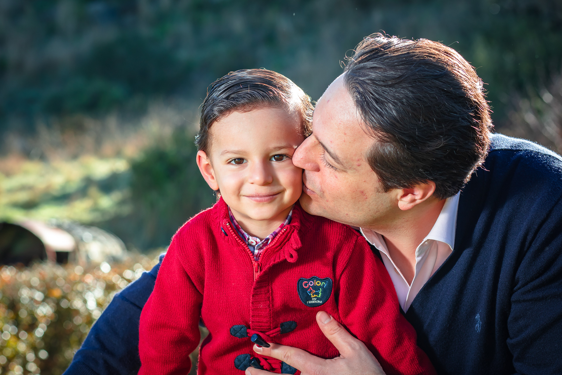 Parent kissing a smiling child on the cheek