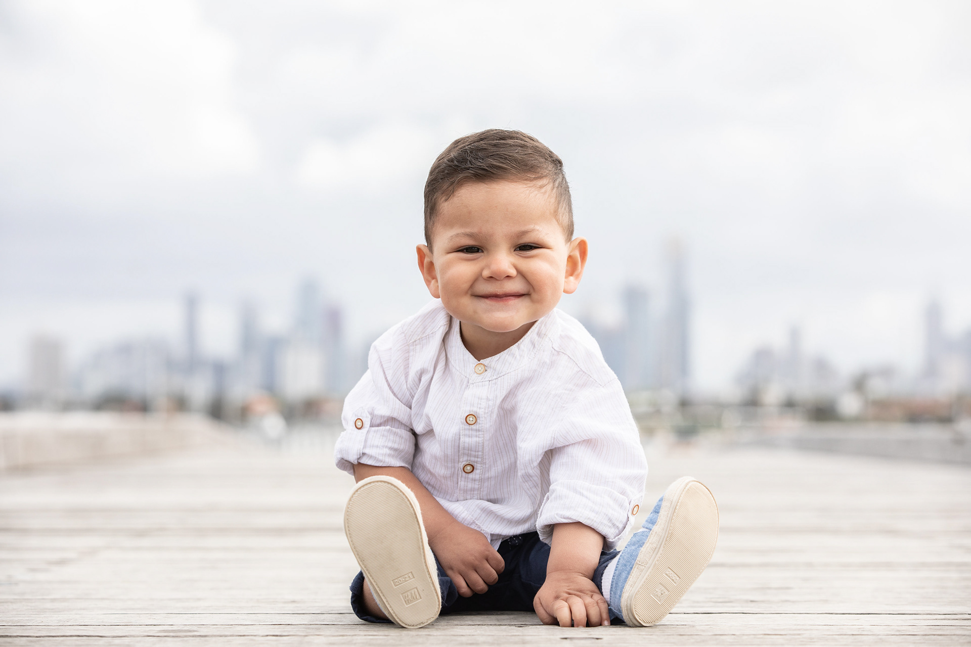 Baby sitting on a wooden deck