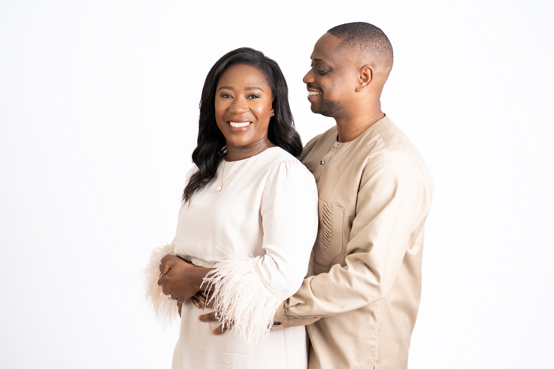 Couple posing together in light-coloured outfits