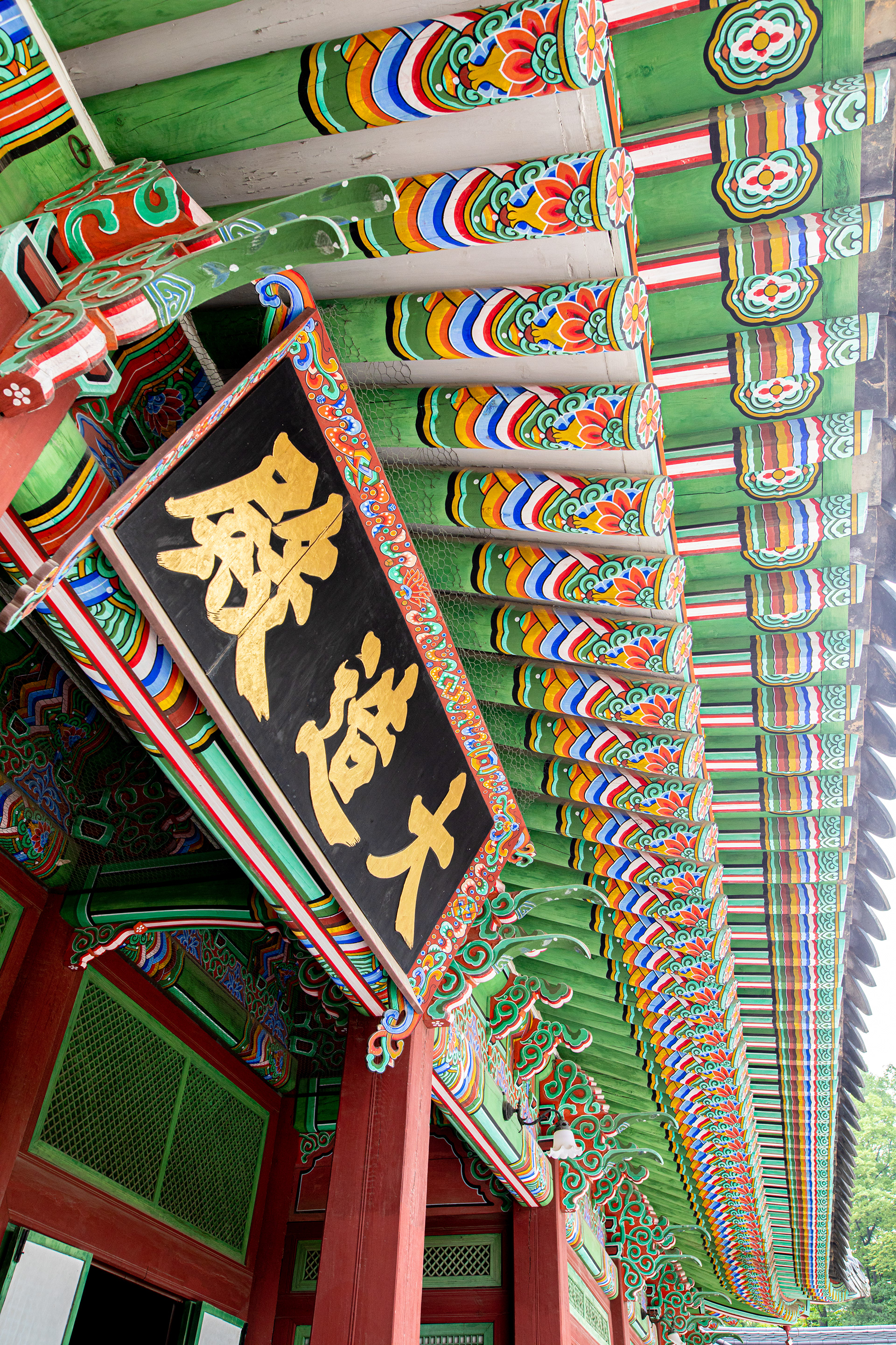 Ornate painted temple roof viewed from below