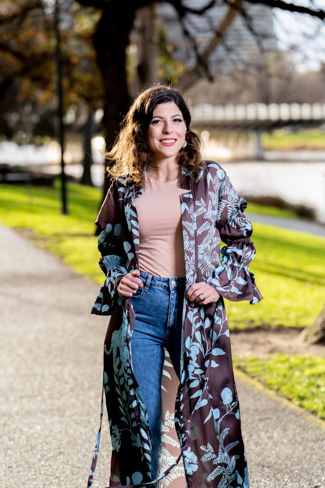 Outdoor portrait in a blue jacket beside a railing
