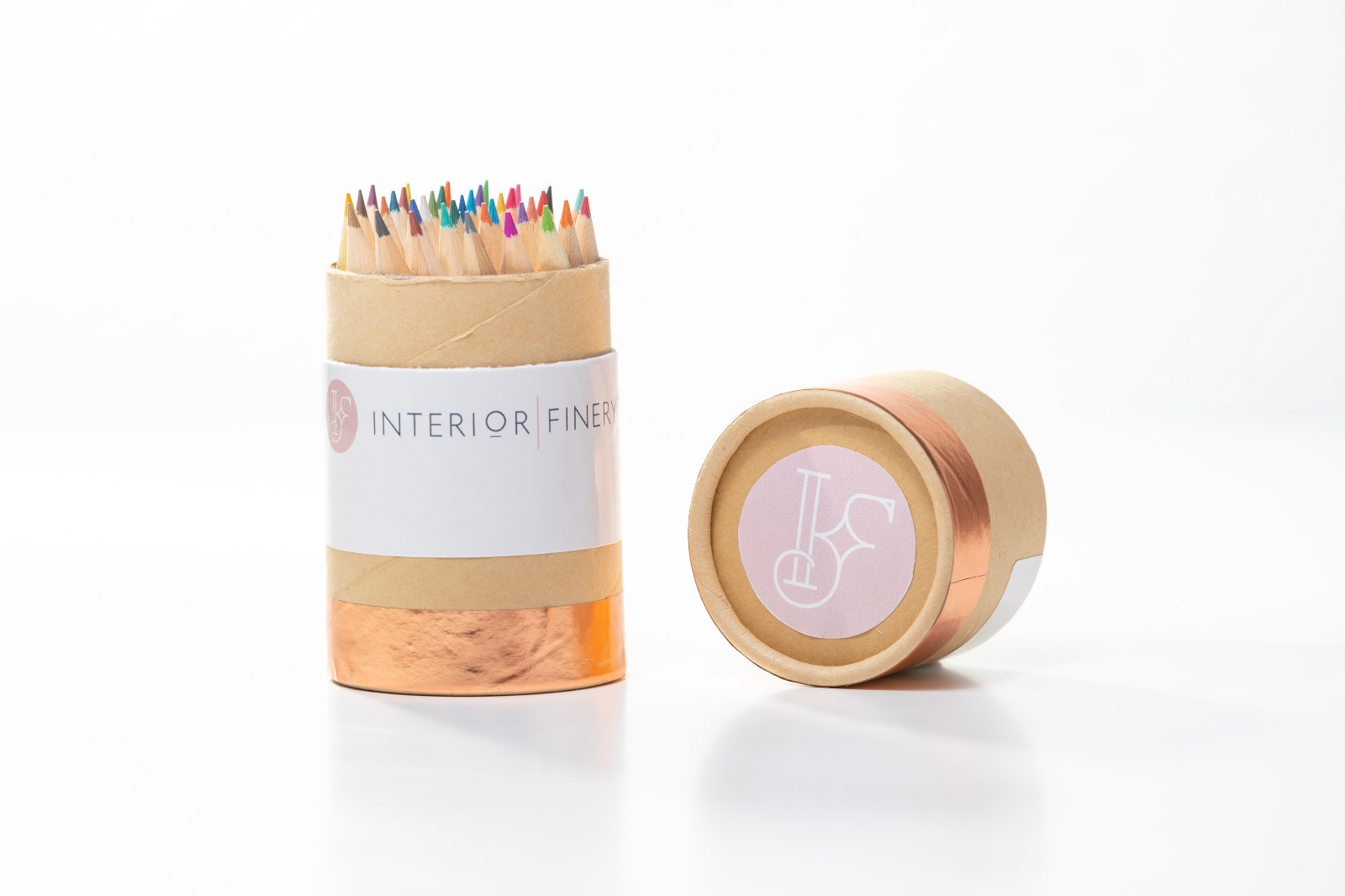 Coloured pencils in a cylindrical wooden container beside its lid