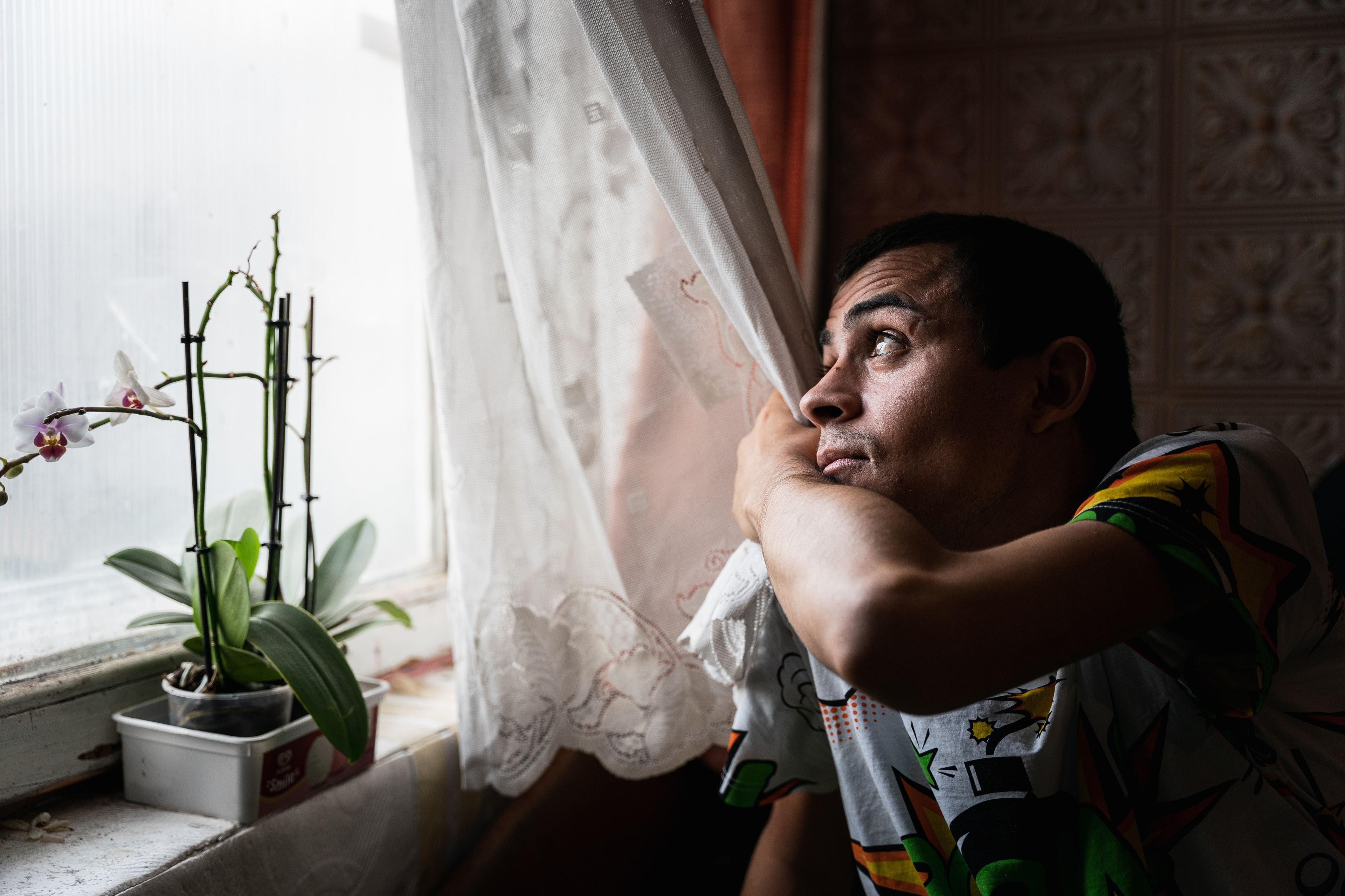 Márk, a young man suffering from incurable DMP muscular distrophy, looks out the window of their house .