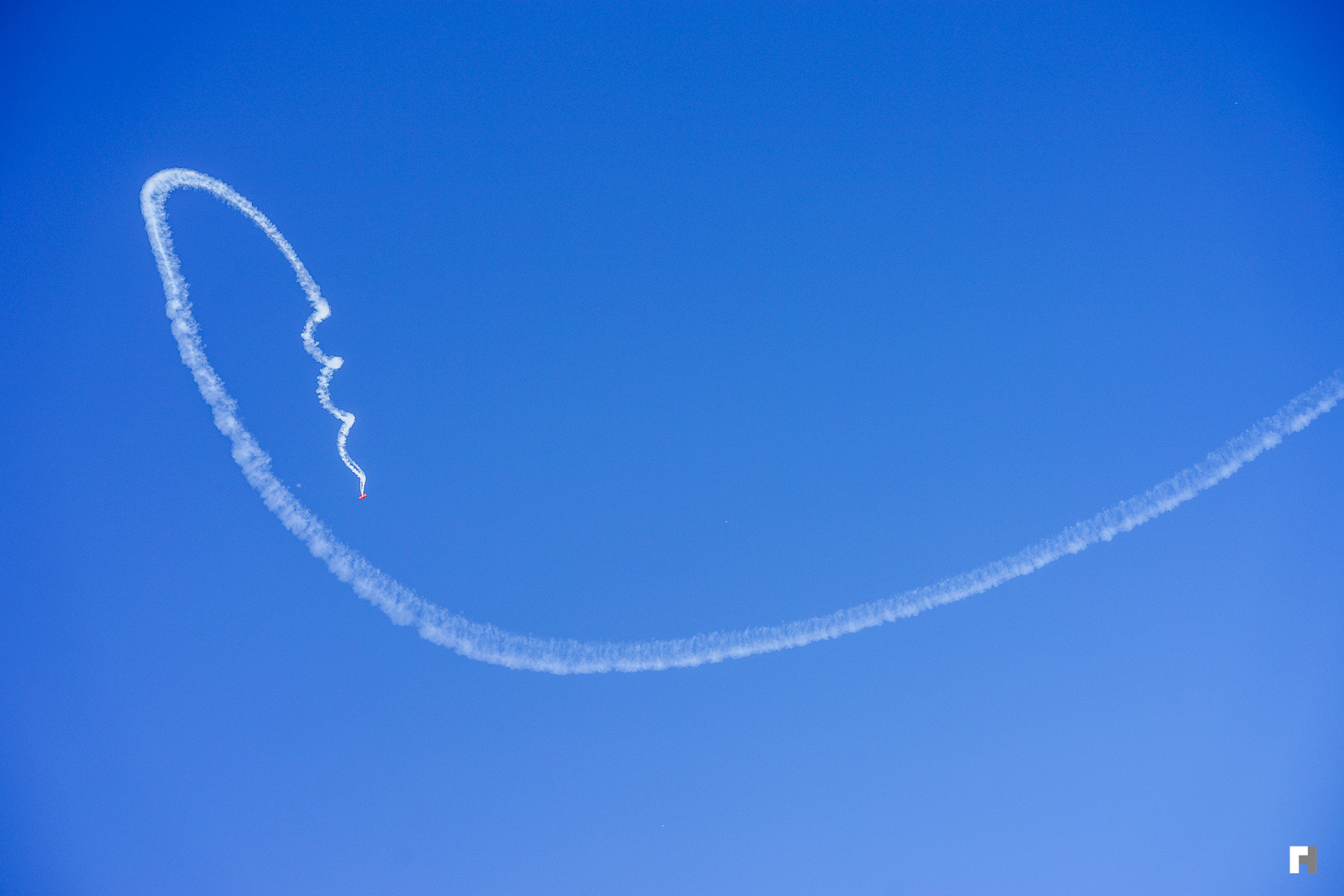 Red biplane doing corkscrews over San Francisco.