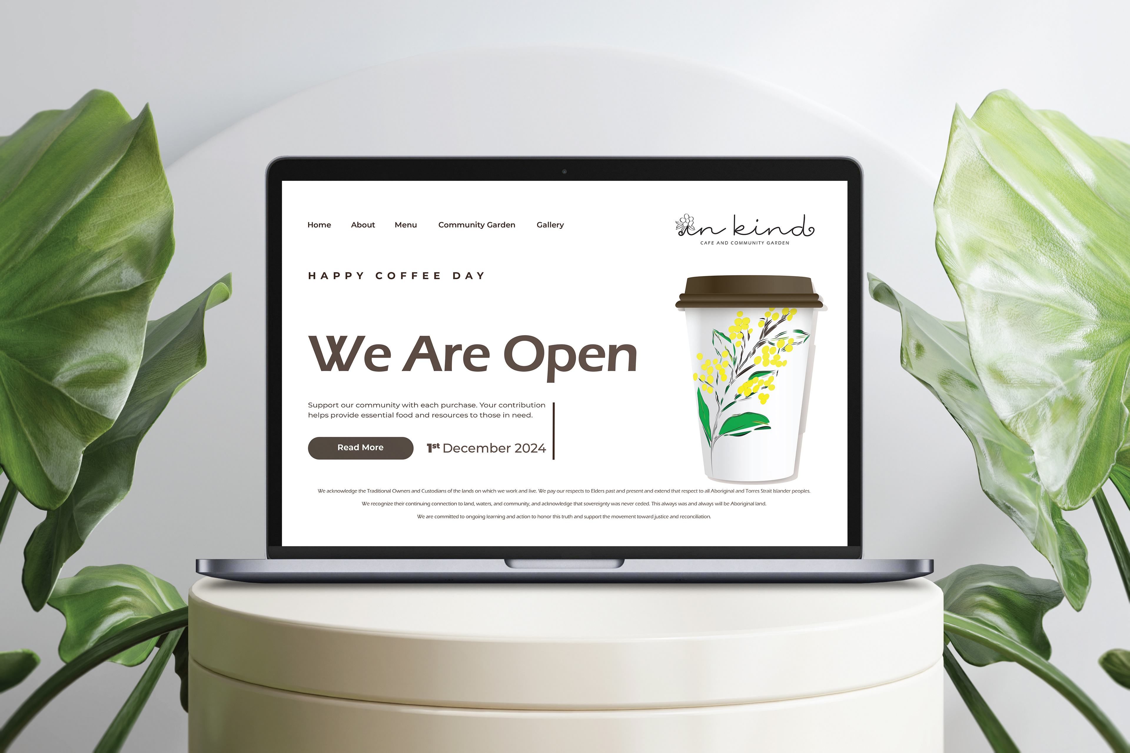 A branding concept mockup for 'In Kind' cafe and community garden featuring a web landing page design. The page displays the custom script logo with a flower replacing the dot on the 'i', the hand-drawn wattle motif consistent with the brand identity, and the takeaway coffee cup from the brand collection. Opening day information is prominently featured on the page as well as the mission to support the local community.