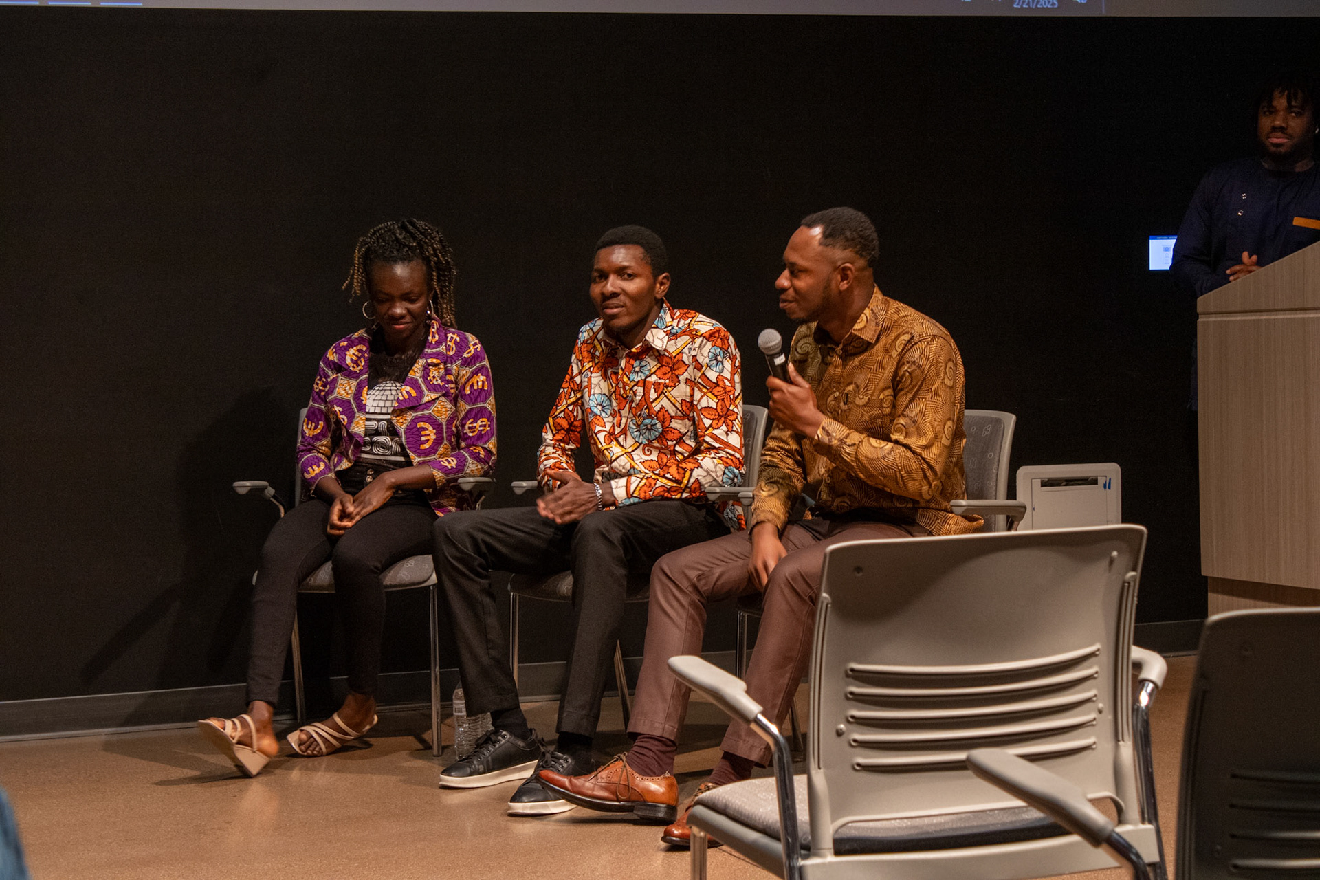 Three people having a discussion on stage at the NAU International Pavilion. 
