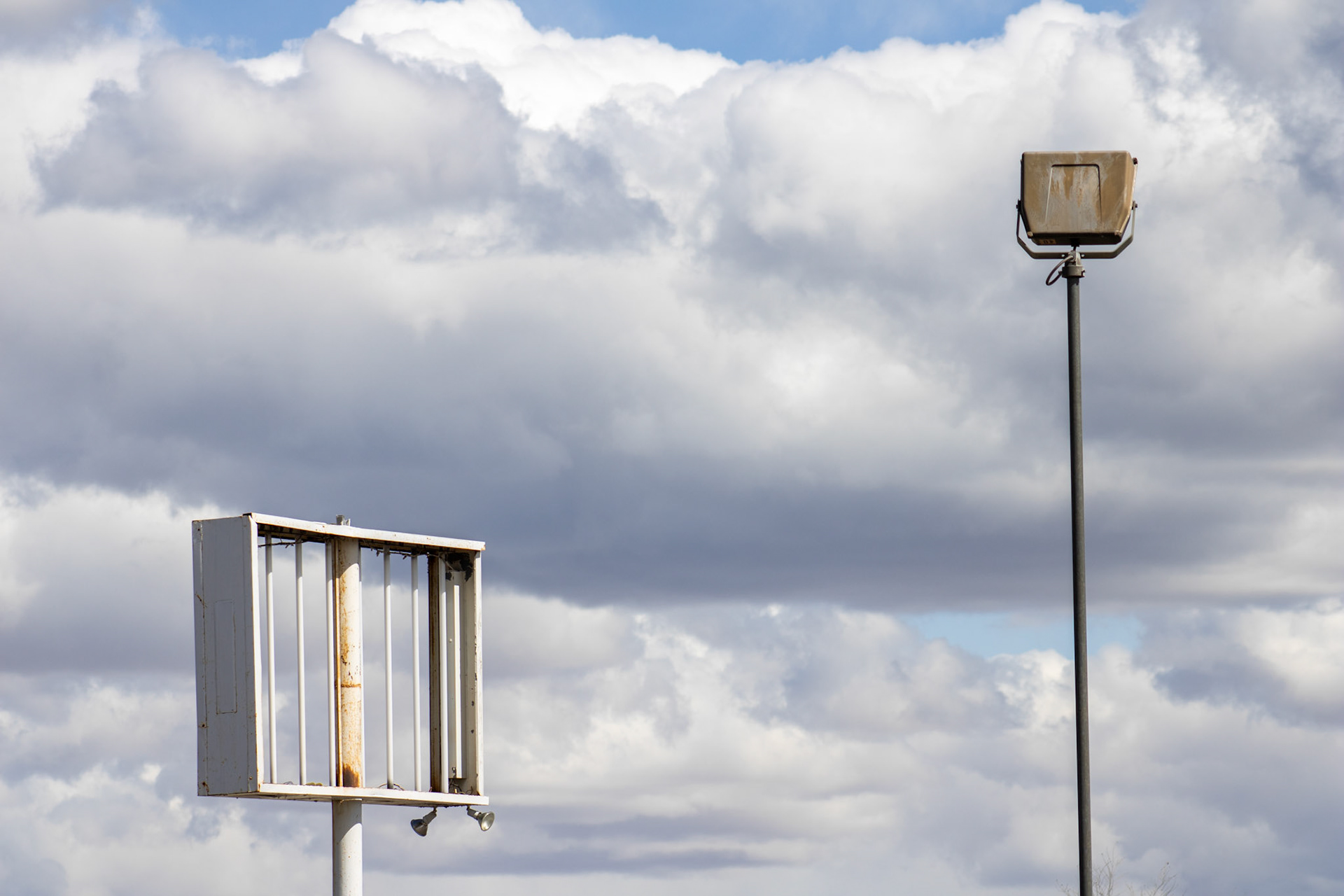 Empty signpost and light fixture against skyline. 