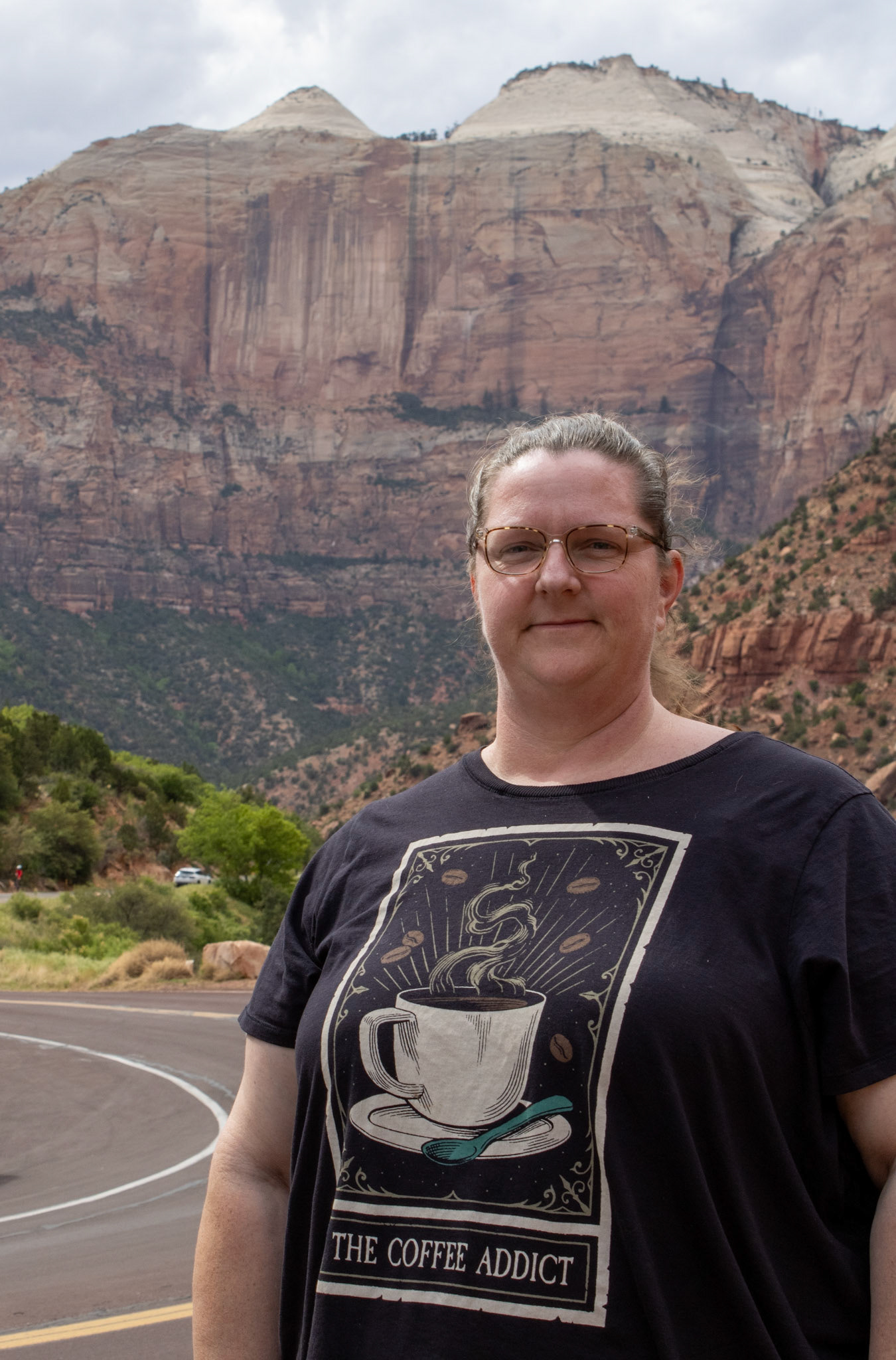 Woman smiling in front of a road at Zion National Park. 