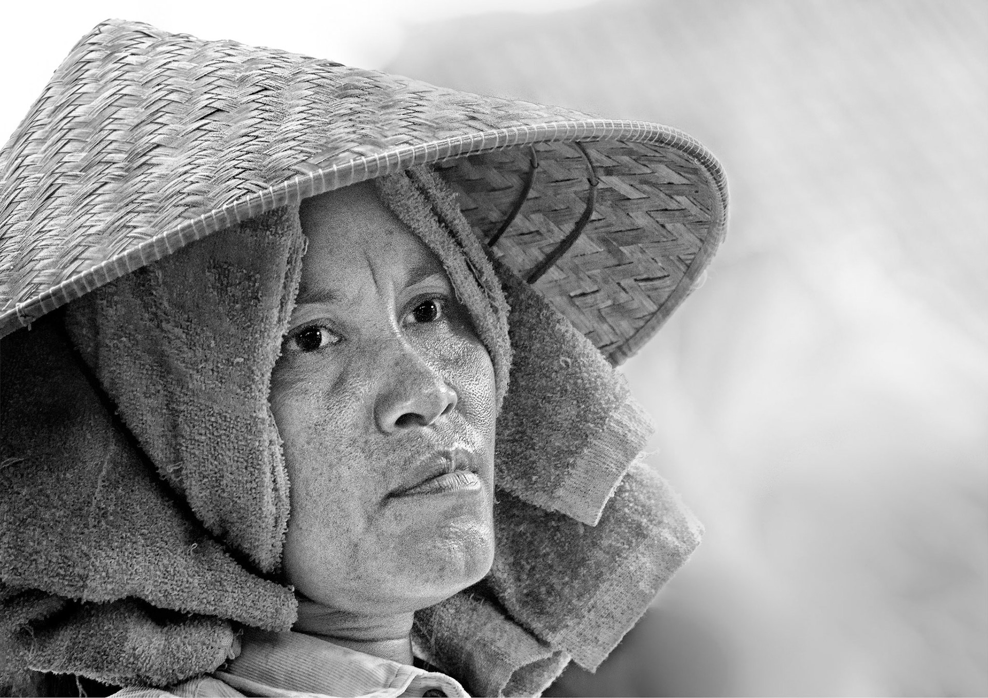 A worker in a Bali rice-field.  To me the expression on her face  reflects the hardship of her life.