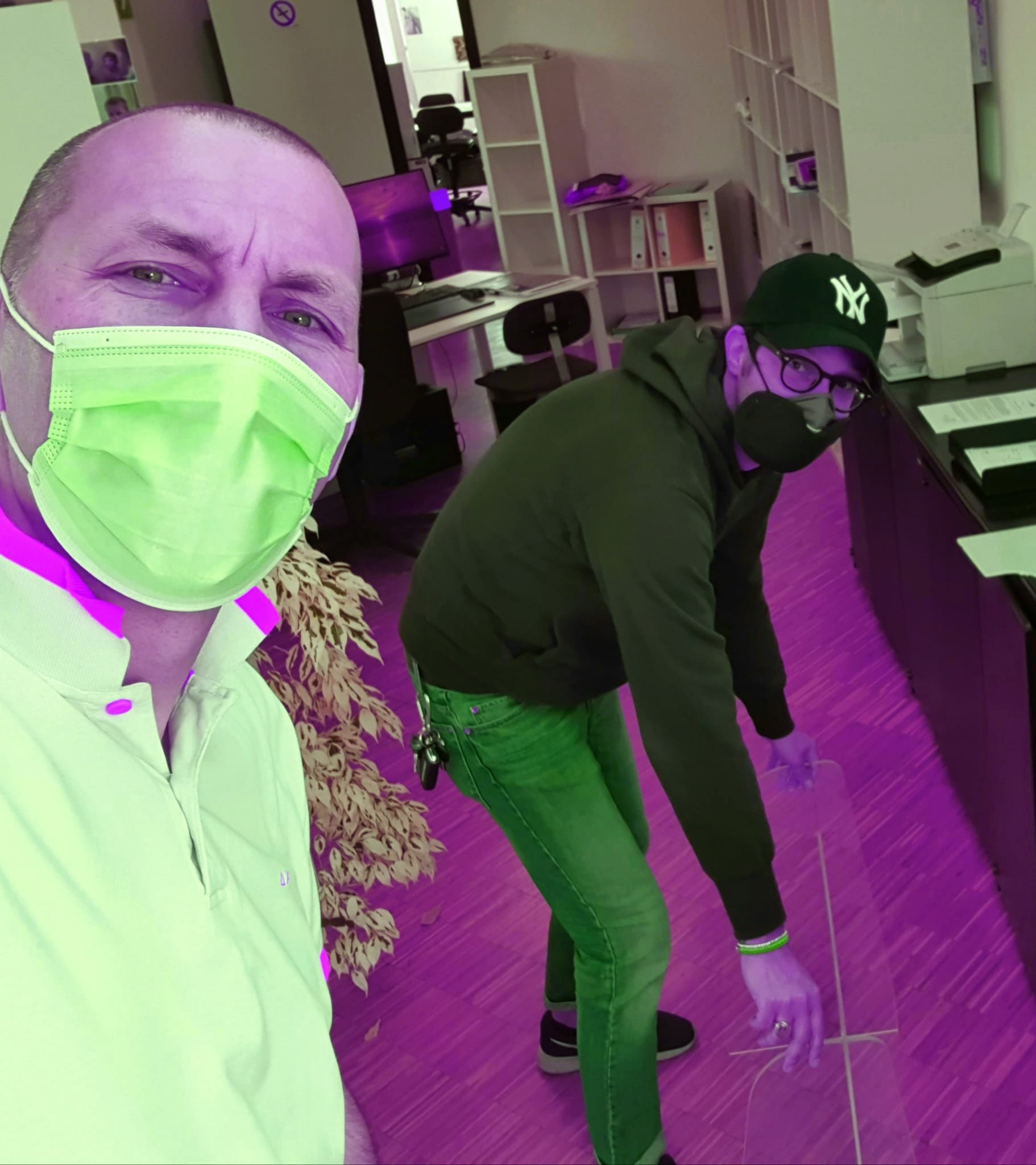 Corrado - Un semplicissimo Selfie scattato durante le operazioni di allestimento dell’Azienda per ottemperare alle Condizioni di Sicurezza. Il rosso-violaceo del pericolo – il verde speranza contrastante della mascherina in primo piano. Occhi preoccupati, ma sereni, di due persone che guardano al futuro, insieme.