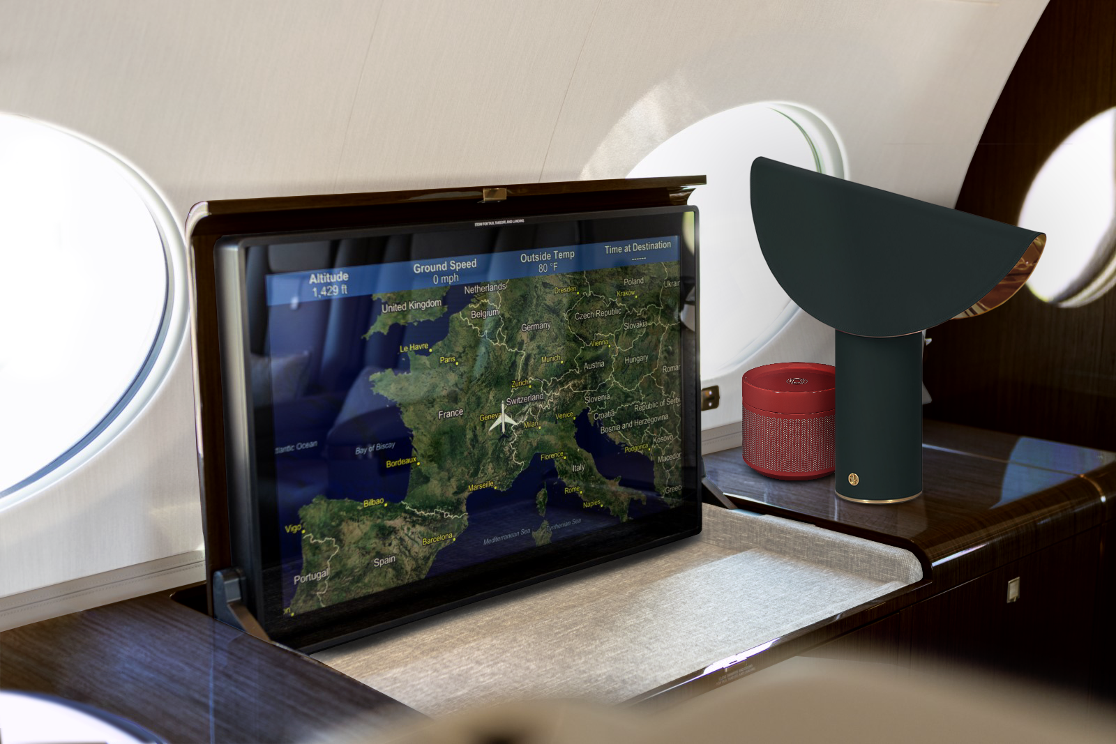 Gulfstream G650ER Entertainment System, showing a screen with informations of the flight. There is also some ornaments over a black wood furniture and panels