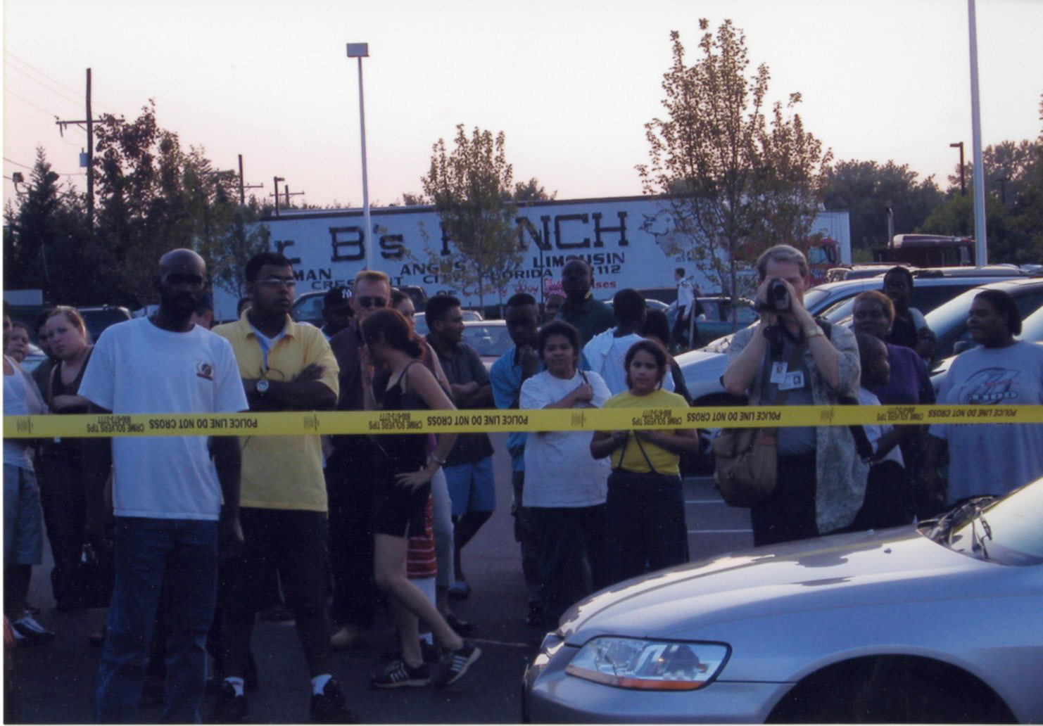 A crowd gathers as law enforcement arrive on the scene after Martin is shot.