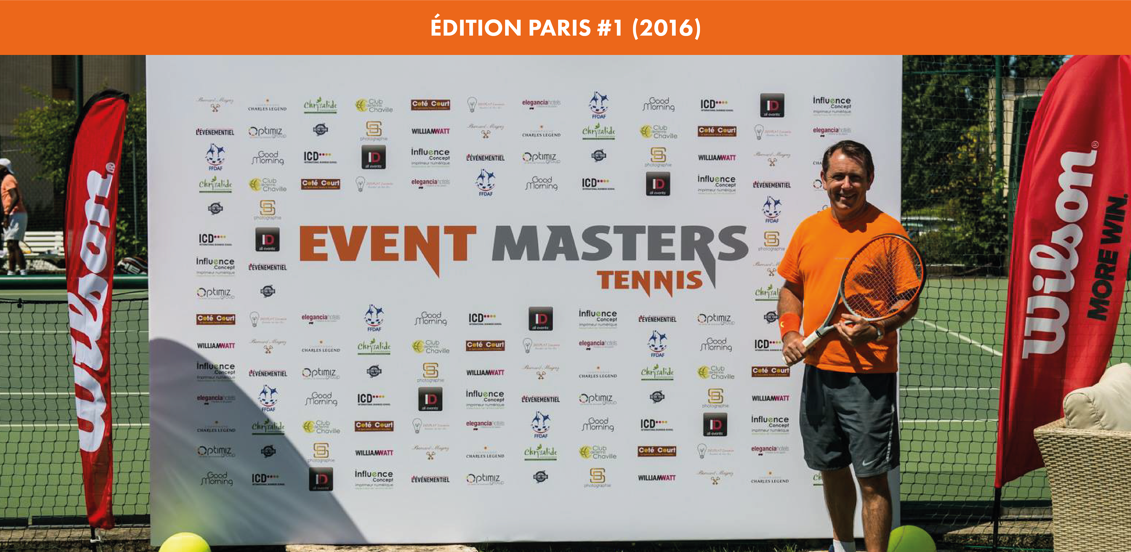 Christophe DOUPLAT pose avec sa raquette devant la bannière de logos partenaires et sponsors lors de l'édition Paris #1 en 2016 au Club Tennis de Chaville