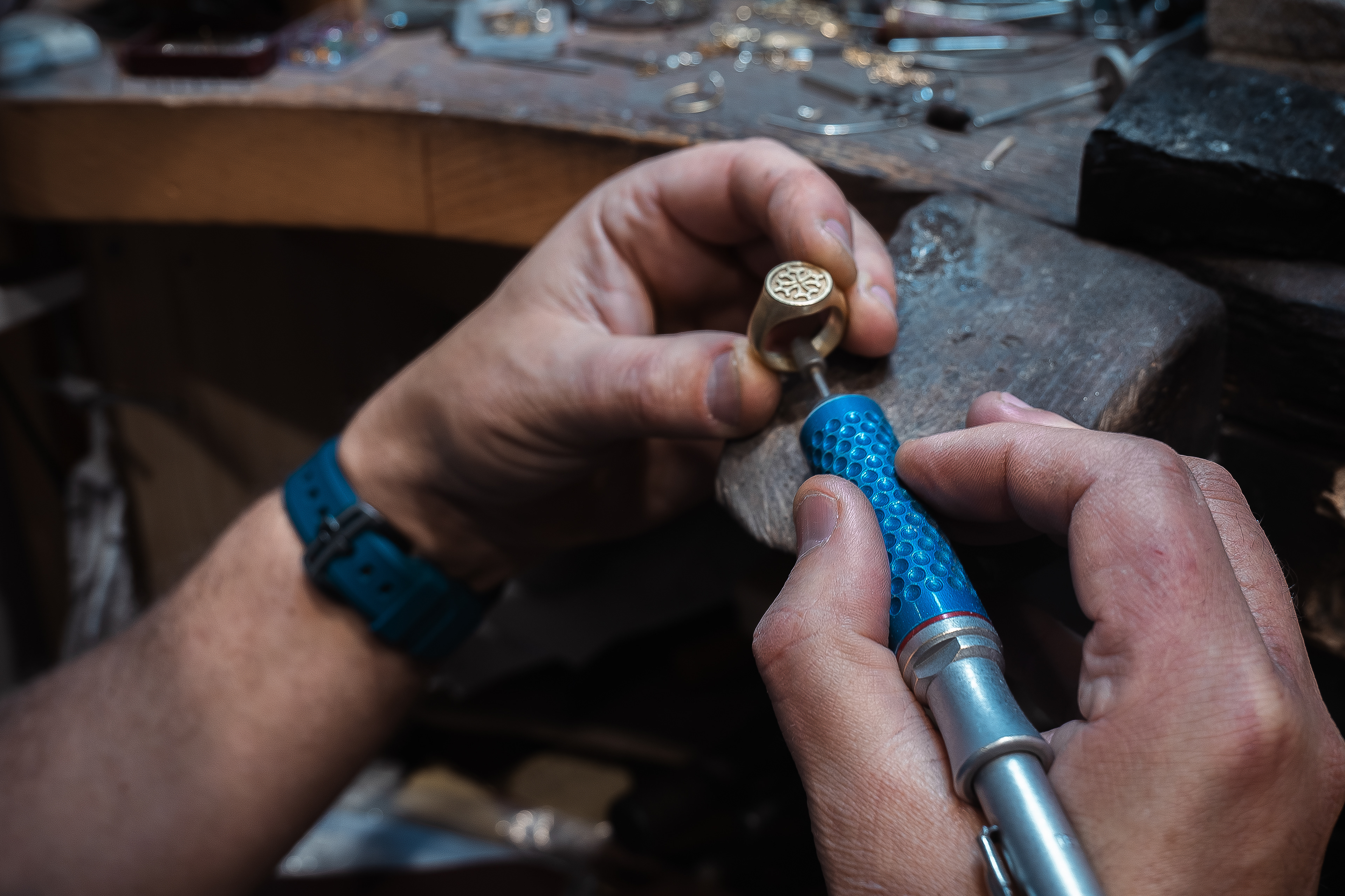 Le bijoutier polit une bague représentant la croix occitane