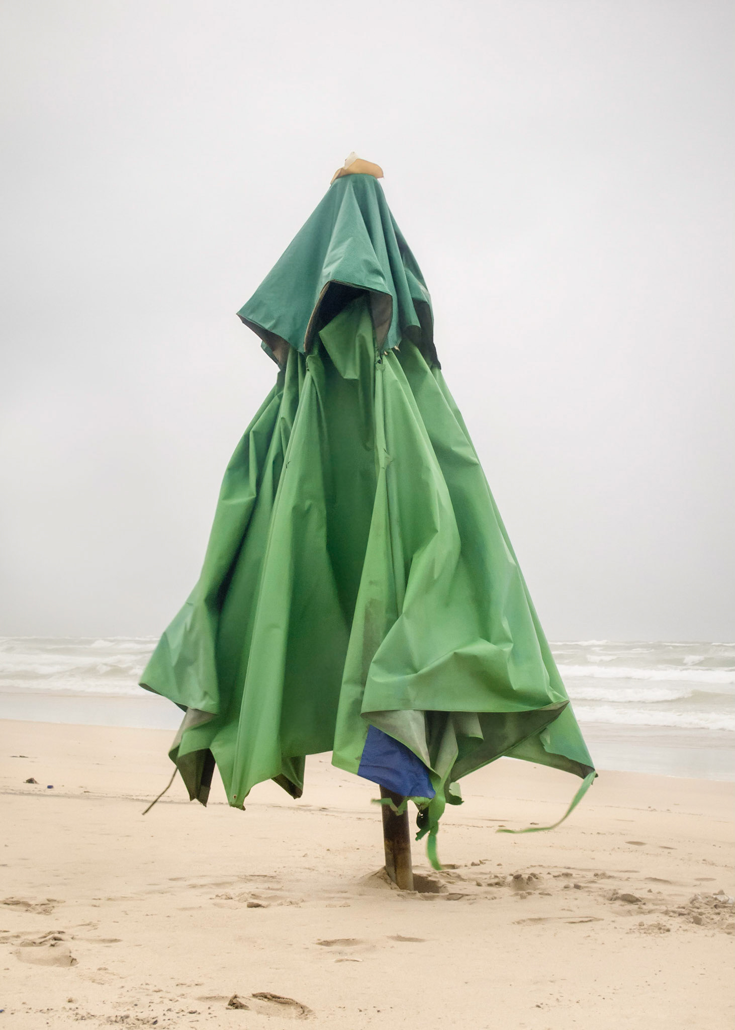 Ibirapitanga - Tupi word meaning red tree, also known as Brazilian Wood. So abundant it was mistaken for the land (and dyed it’s children). Part of Liquid Beach series:As hut owners begun to be expelled from the sands of Salvador’s beaches, their resistance took shape through umbrellas and plastic tables, mythical symbols of the local culture. Their colorful shapes erected against the gloomy horizon set the stage for a visual dictionary of the country's social-economic history, each title referring to an issue yet to be resolved.Liquid - Drinkable amorphous substance. When ingested in despair causes drowning (or drunkenness). Humanity’s current state according to Bauman. Quality of the blood that flows.Beach - Brazilian history’s primordial stage. Where work, leisure and belief mingle. Where blood is boiled, poured and mixed. From where one can see the horizon and feel “saudade”. Where umbrellas arise as sculptures above the sand, watching over the people as saints and orixás.