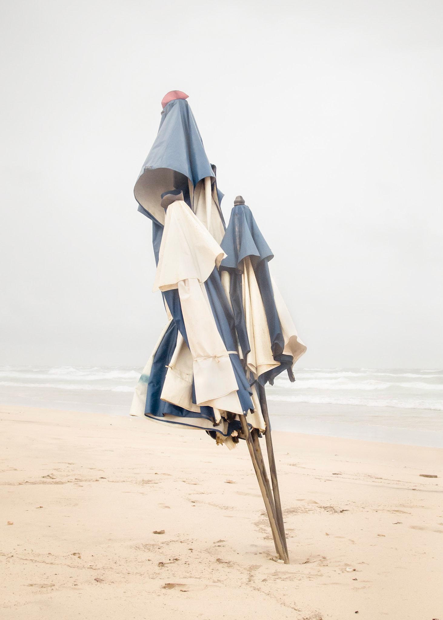 Freedom - Spiritual freedom, the liberation of sin out of the native’s flesh, genocide. Human freedom, the end of slavery, farce. Utopian freedom, the yell at the banks of Ipiranga River, silence.Order and Progress - Positivist motto present on the national flag, but without Love (first and foremost).Part of Liquid Beach series:As hut owners begun to be expelled from the sands of Salvador’s beaches, their resistance took shape through umbrellas and plastic tables, mythical symbols of the local culture. Their colorful shapes erected against the gloomy horizon set the stage for a visual dictionary of the country's social-economic history, each title referring to an issue yet to be resolved.Liquid - Drinkable amorphous substance. When ingested in despair causes drowning (or drunkenness). Humanity’s current state according to Bauman. Quality of the blood that flows.Beach - Brazilian history’s primordial stage. Where work, leisure and belief mingle. Where blood is boiled, poured and mixed. From where one can see the horizon and feel “saudade”. Where umbrellas arise as sculptures above the sand, watching over the people as saints and orixás.