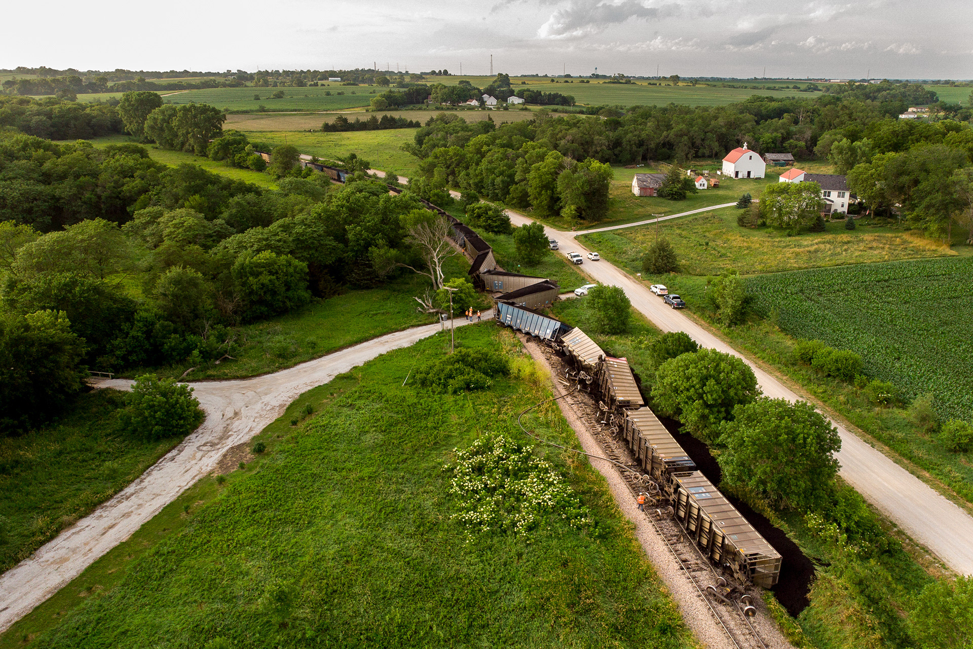 Loaded OMAX coal hoppers lay on the ground as workers assess the damage after BNSF C-BNRMARB0 derailed outside Bennet, Nebraska. 06.25.21.