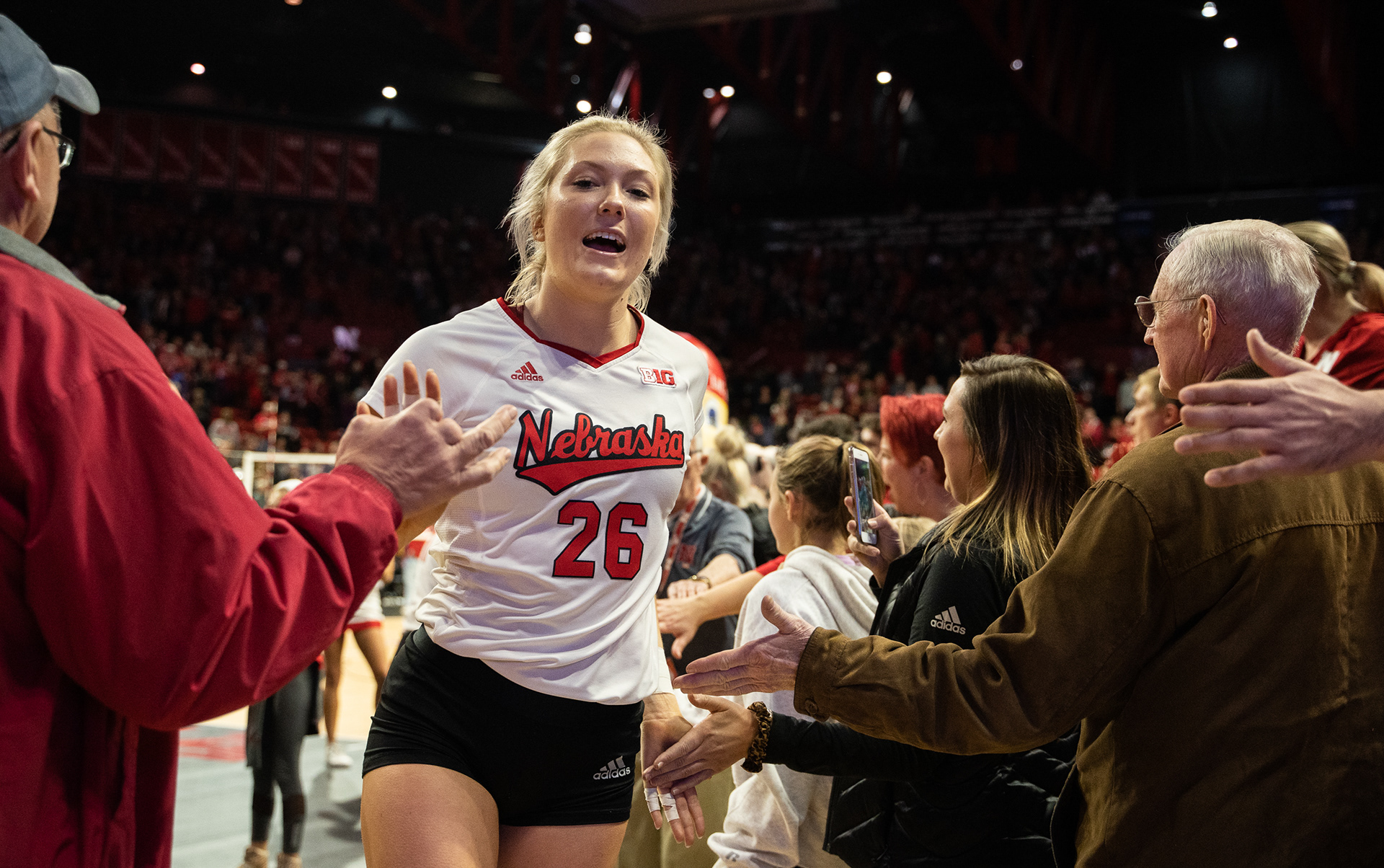 Nebraska's Lauren Stivrins (26) high fives fans as she runs off the court following the 3-1 win over Mizzou at the Bob Devaney Center in Lincoln, Nebraska. 12.07.19. 