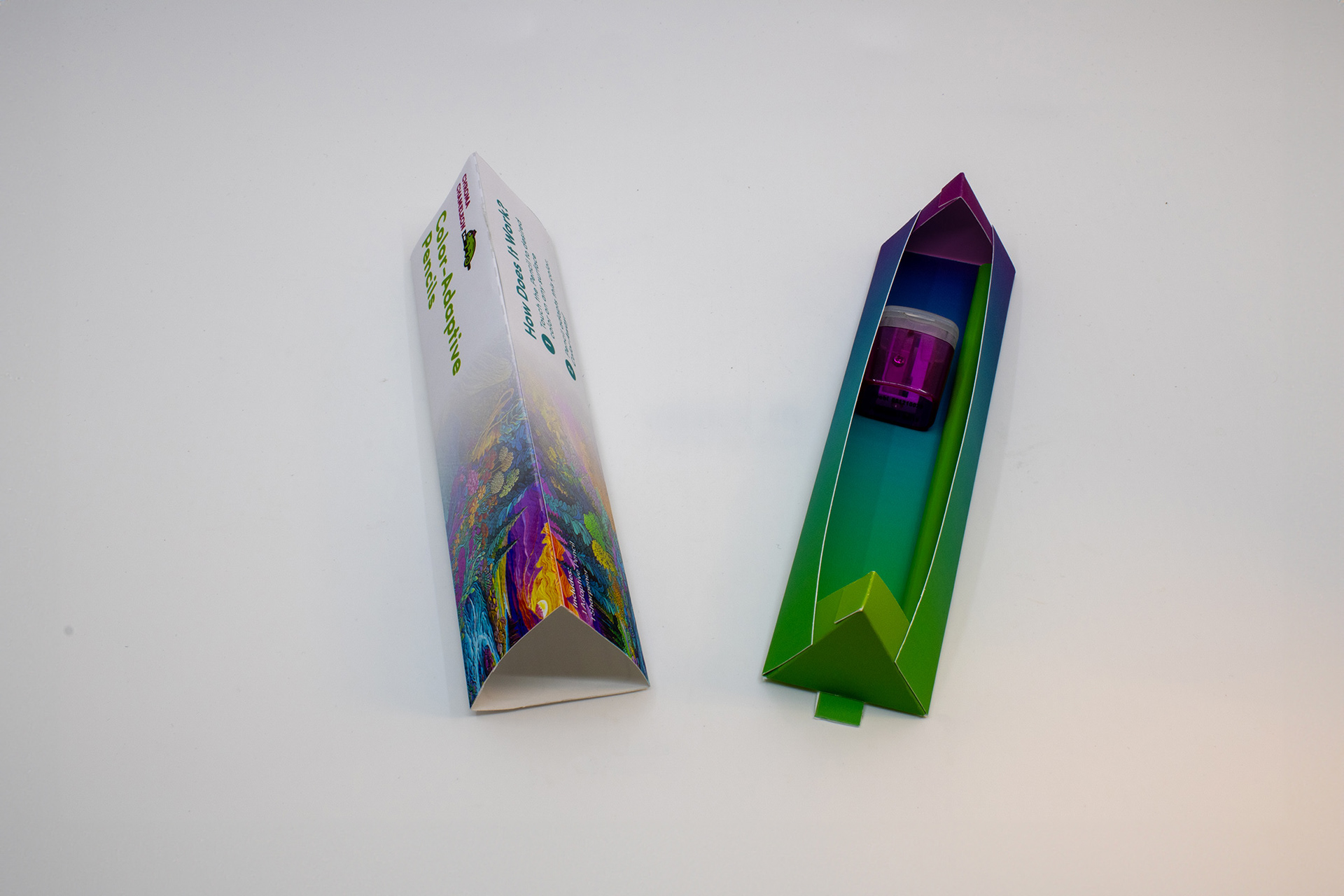 Image of the outside covering and the slider of the Chroma Chameleon package design, with a magenta pencil sharpener and a Chroma Chameleon pencil changed to green inside the slider