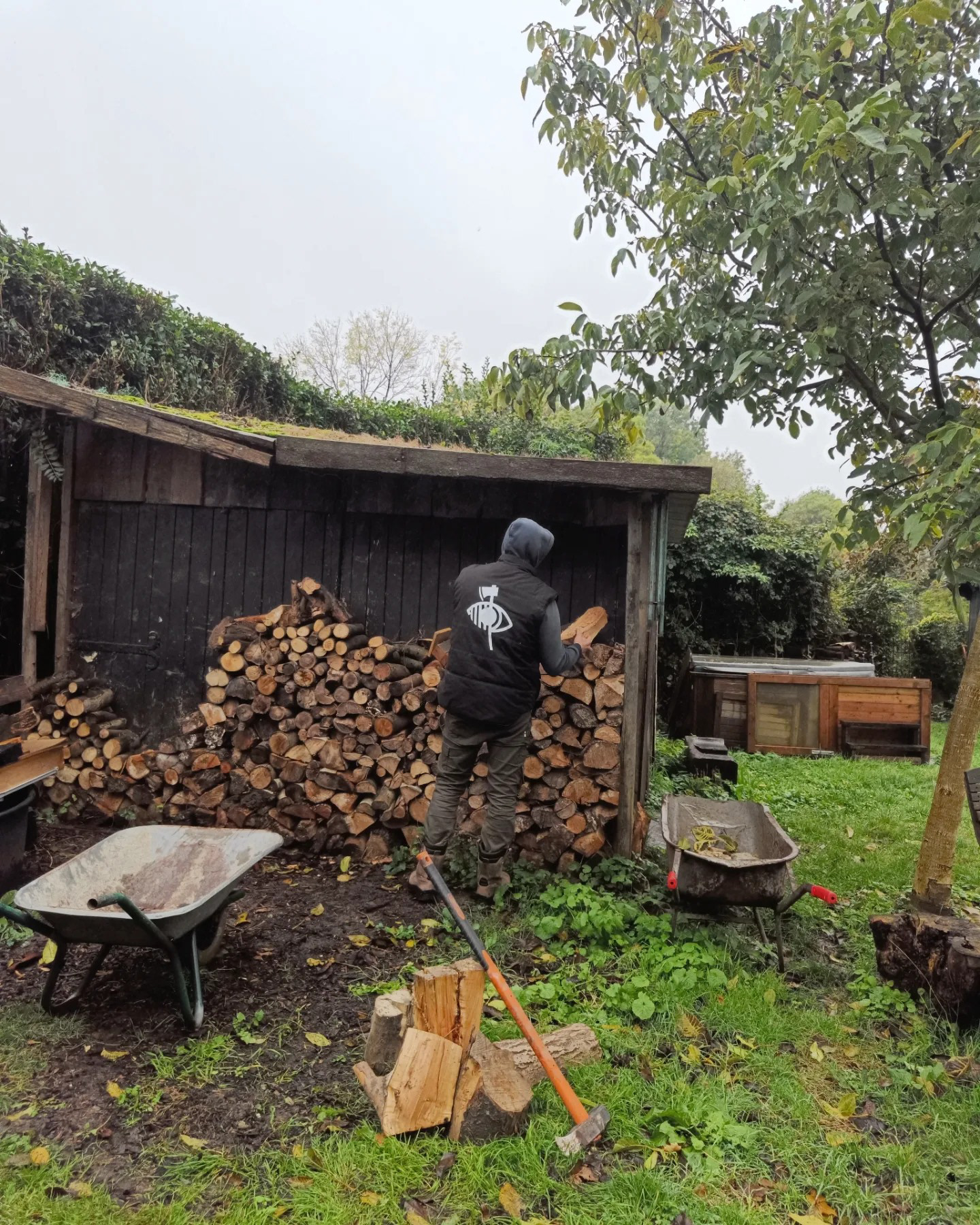 slechtziende hakt hout met ludiek blindenlogo met bijl erdoor aan