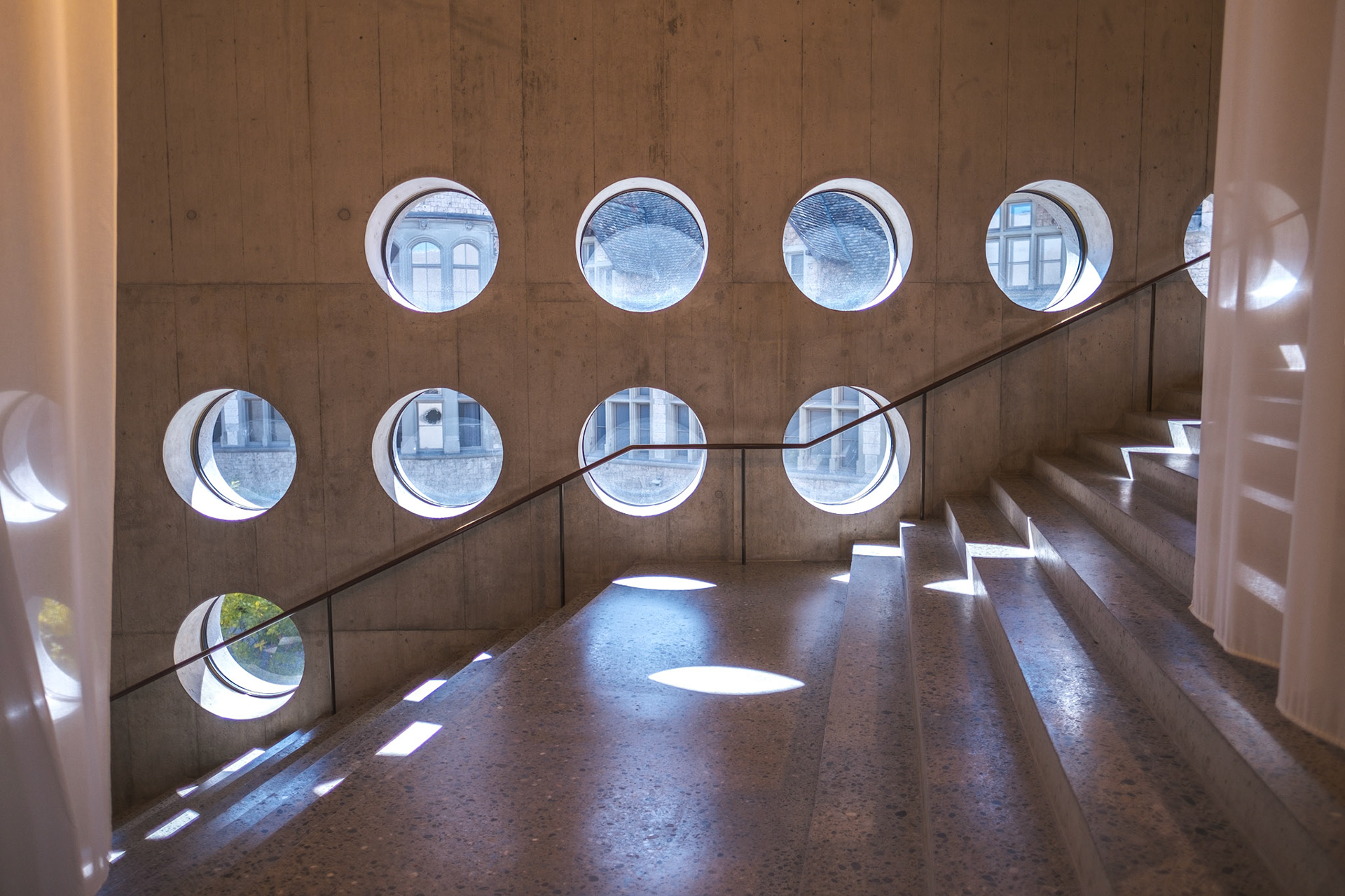 concrete staircase with round windows in the new extension