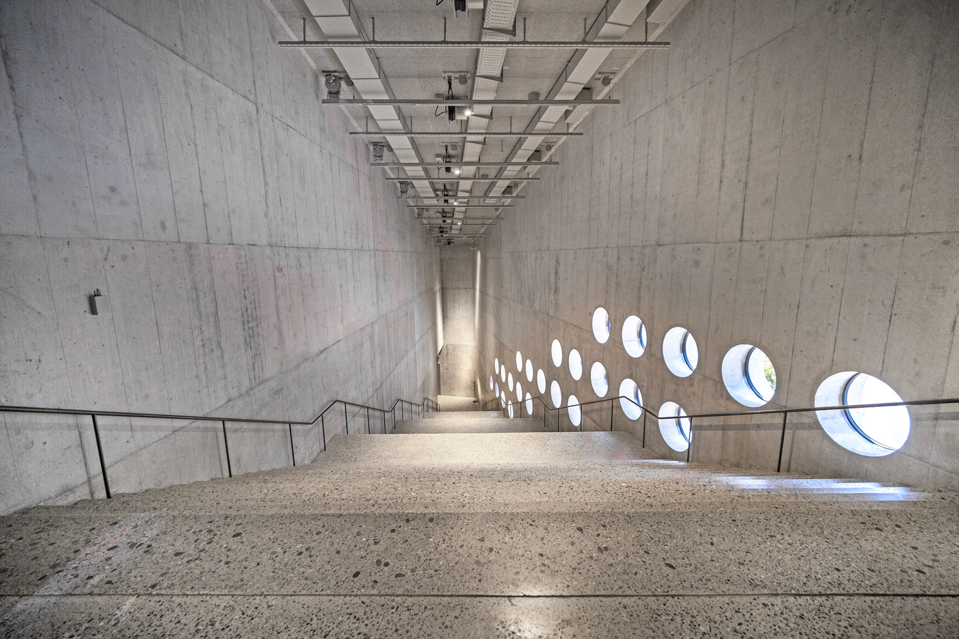 concrete staircase with round windows in the new extension