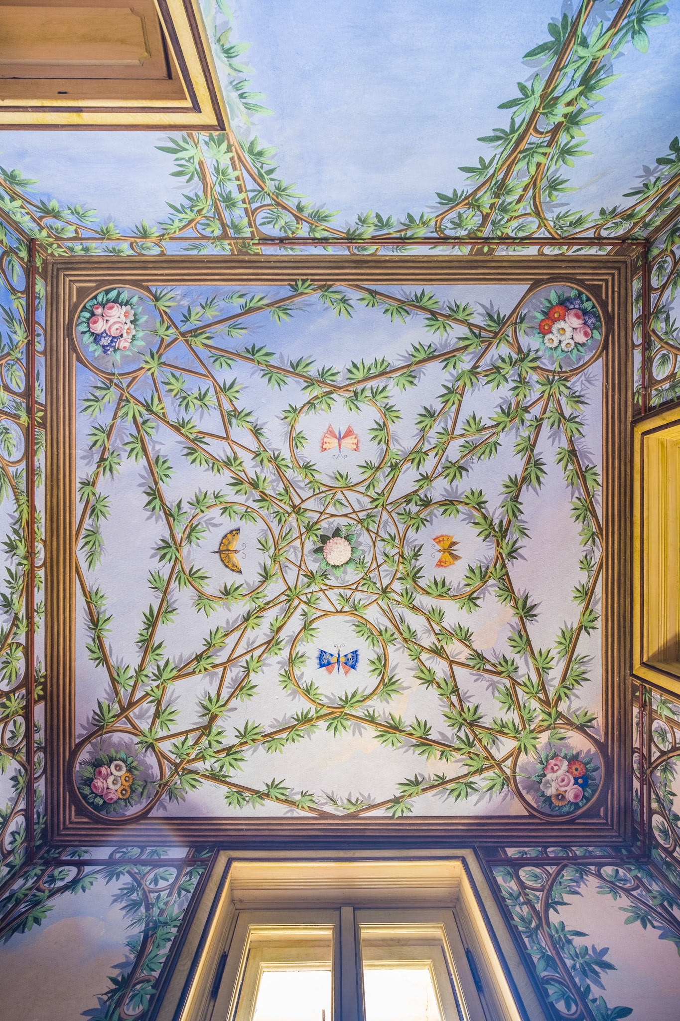 trompe-l'oeil painting of a pergola with climbing plants and flowers