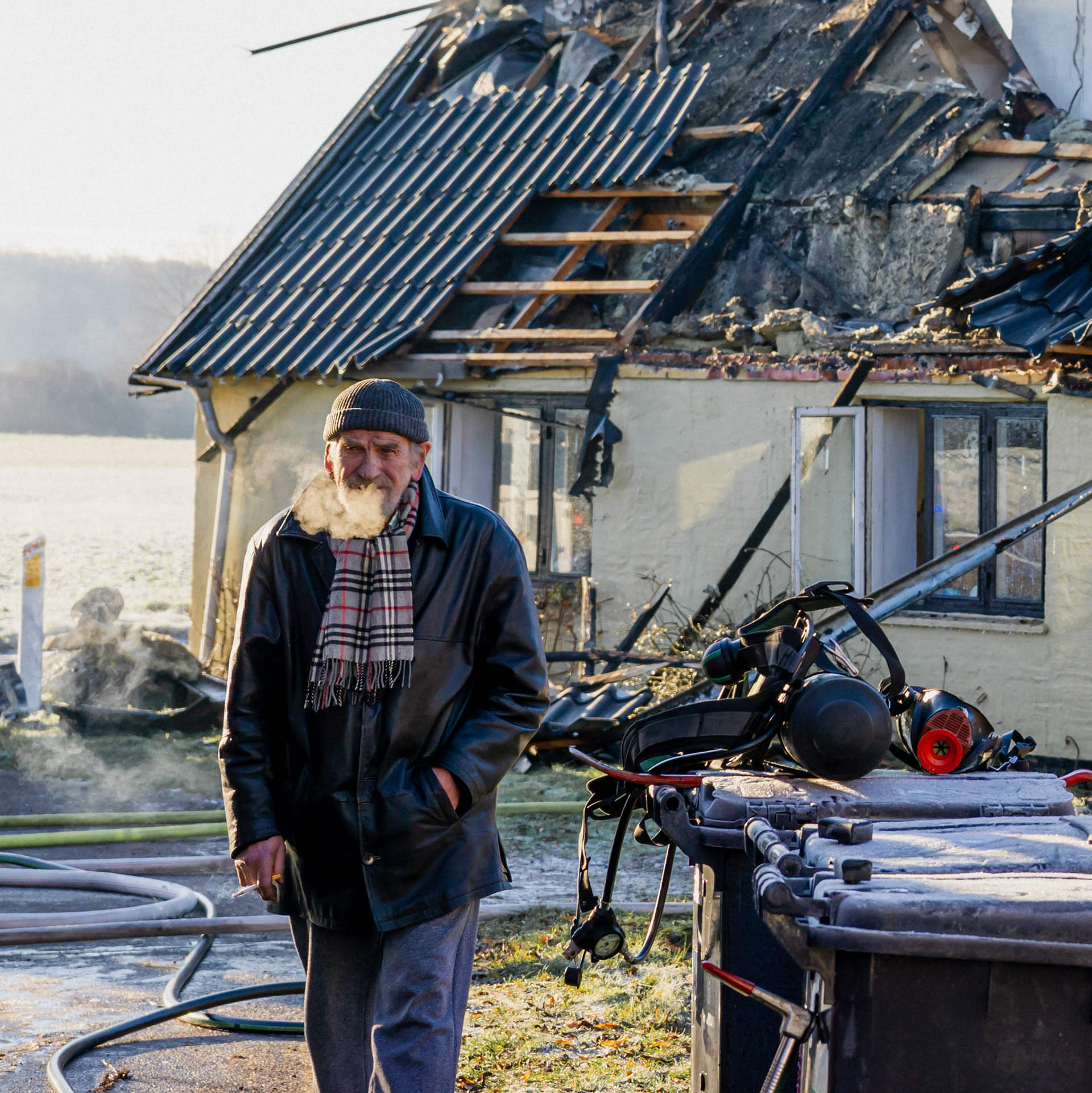 Portræt af en ældre herre ved en brand i efterslukningen