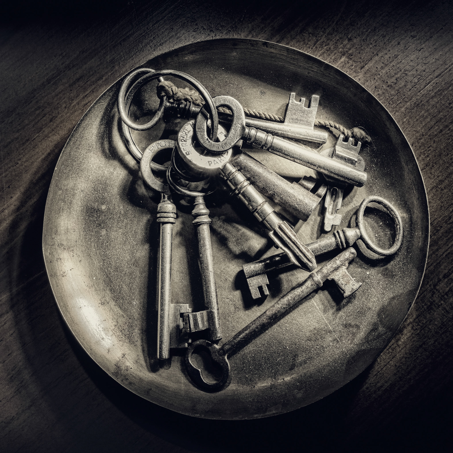 A quiet still life of antique keys resting in a metal dish. Worn surfaces and simple forms evoke memory, access, and absence.  ⸻  Tags  keys, antique keys, still life, black and white, texture, time, memory, objects, fine art, minimal