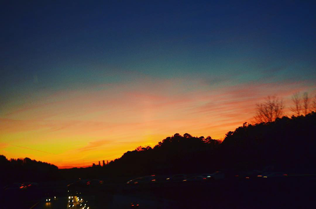 Sunset behind mountains - taken from the window of a charter bus