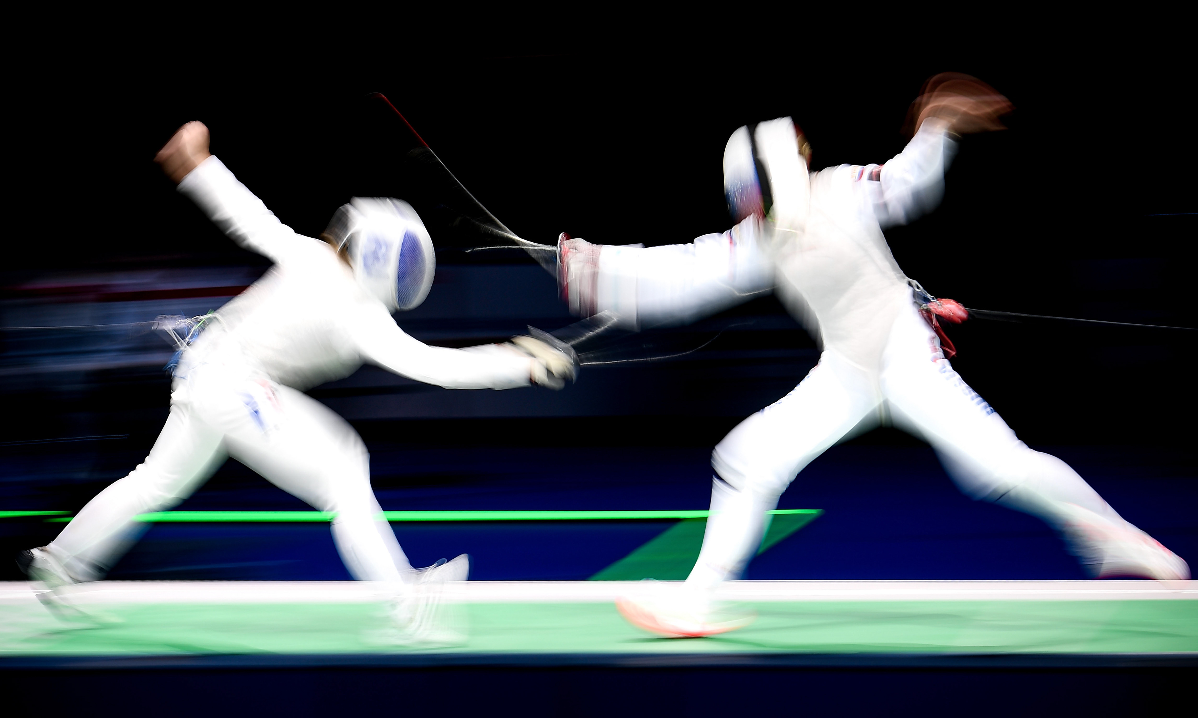 A long time exposure showing athletes of France (L) and Russia (R) competing in the foil women's team final of the 2019 Fencing European Championships in Duesseldorf, Germany, 21 June 2019. (Photo by Sascha Steinbach/epa)